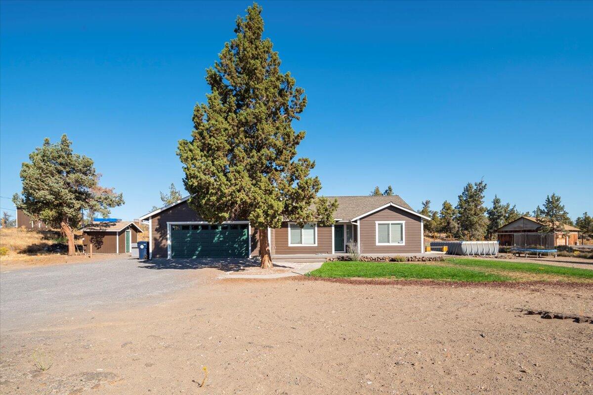 Located on the edge of NW Redmond in the quaint Tetherow Crossing subdivision, this 2,152sf home sitting on 5.11ac's offers both privacy and tranquility. This 3bed/2bath home offers a bright & open great room design with a newly updated kitchen and dining area with vaulted ceiling along with lots of windows and skylights. There is a Den/Family room to your right as you enter with French doors for separation. The great room overlooks the natural terrain landscape through the large windows. Oversized hall bath. Walk through laundry room leads out to the double car attached garage. The primary suite with vaulted ceiling, walk in closet & sliding glass door leading out to the deck. The bathroom has a full slate tile shower, double vanity & a large linen closet. Outside you will find lots of space, outbuilding, storage shed, chicken coups, spot for your garden & it's fenced for your animals. Push out for shop area to the north of the driveway entry. Very private setting for your family.