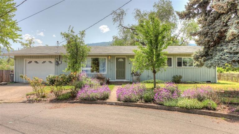 This deceptively large, charming, ranch home is located on a quiet cul-de-sac. With two offices, a library that features a vaulted ceiling, track lighting and french doors that lead to the back yard. The cozy living room includes a fireplace. The open family room/dining room/kitchen area is a great space for catching up with family members. The master bedroom has two closets, a bathroom, and french doors to the back yard. The spacious, fully fenced, back yard has plenty of room to add a vegetable garden. The extensive deck has a wonderful view of Mt. Ashland. In 2002, a new roof was installed, and the library and laundry room were added. At the same time, part of the garage was converted to use as either a TV room, playroom or a work space. This conversion can easily be undone. In 2012 bath fixtures were upgraded. In 2014 the hardwood floors were refinished in three bedrooms and an office, new paint throughout and new carpet installed.