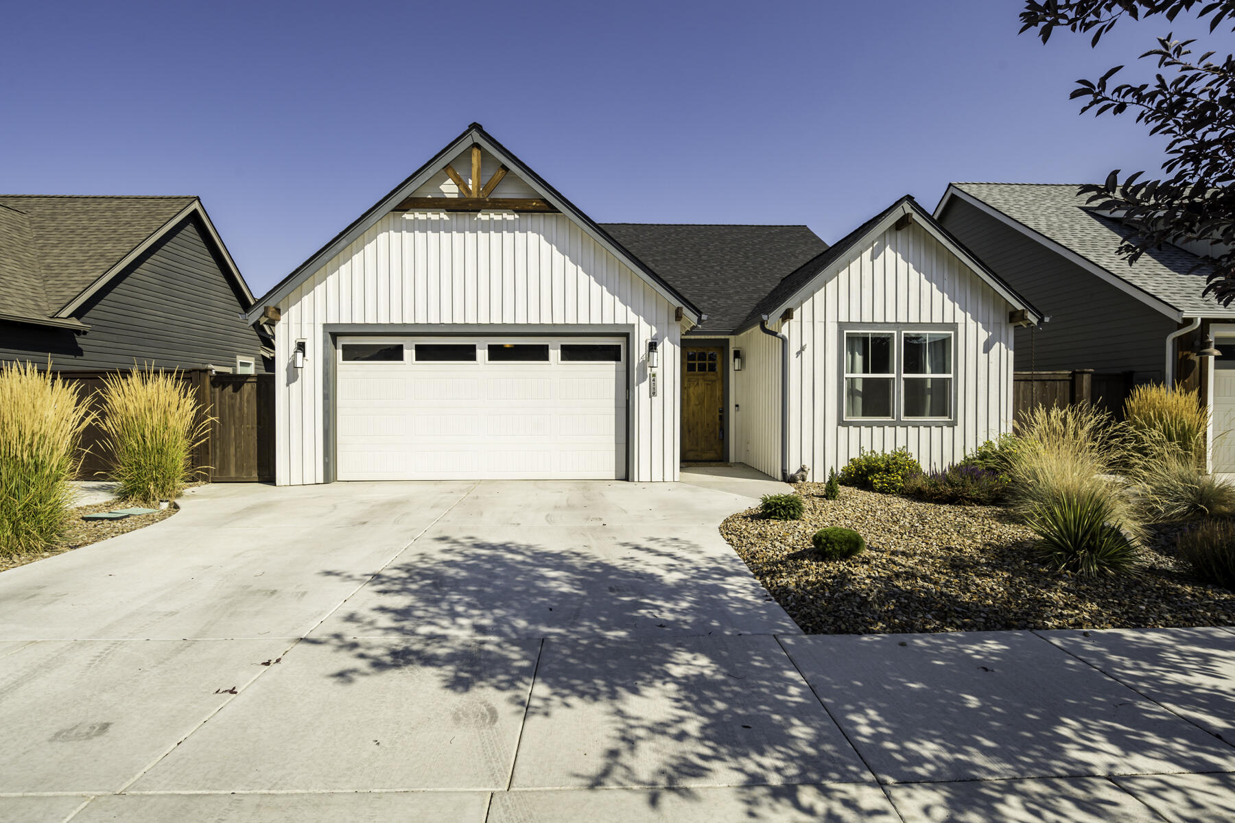This Earth Advantage-certified home blends modern farmhouse style with sustainability, featuring shiplap exterior, hardwood floors, and a thoughtful single-level floor plan. Cathedral ceilings and a stacked stone fireplace in the living room complement a gourmet kitchen with quartz countertops, center island with granite undermount sink, and soft-close drawers. The primary suite, conveniently separated alongside a home office/den, offers tray ceilings and a bath with dual vanity and heated floors. Energy-efficient features include a tankless water heater, upgraded insulation for improved air quality, and an oversized garage with electric charger, connected by a mudroom. Enjoy a low-maintenance xeriscaped front yard along with a spacious fully-fenced back yard and a covered patio perfect for outdoor dining. Located on a quiet street connected to a private community green space, which includes a dog park and pavilion. 10 minutes to downtown Redmond and the airport; 20 minutes to Bend.