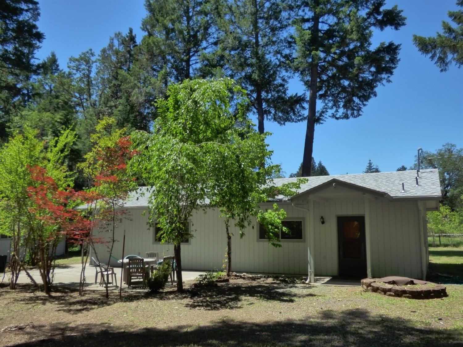 Gorgeous security-gated country estate for a song! Park-like landscaping with inviting and extensive patio work and peaceful tall trees. Home has open great room, terra-cotta tile flooring throughout, and large laundry room. Bring your updates and make it your own! Large 960 square foot double-bay garage/shop has bonus shop-room with workbenches in the back. Excellent 20 gpm well in area of good drinking water. Fruit trees, nuts, and various ornamentals and bulbs. Enjoy some seclusion near the end of the cul-de-sac on this country lane that is off the beaten path. All loan types welcome!