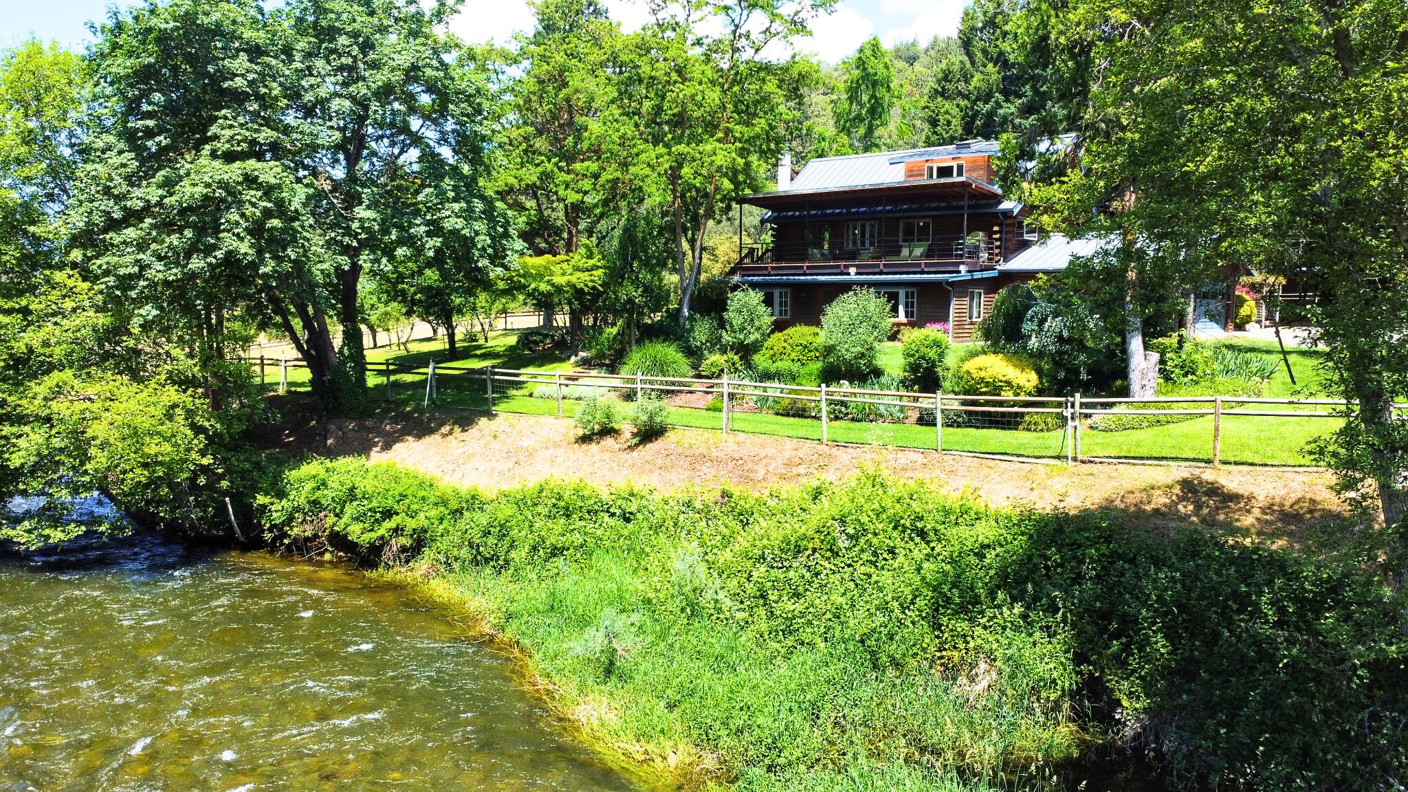 Welcome to this one-of-a-kind riverfront retreat, a haven for outdoor enthusiasts, boasting complete privacy and unspoiled river views. The property houses a main residence and a 540sqft guesthouse, complete with cutting-edge amenities like integrated Wi-Fi, fiber optics, heated floors, an automated backup generator, and a 700-bottle wine cellar. Water system is upgraded and includes filtration and softening, ensuring water quality.  Step outside to lush, irrigated organic landscaping, a mature orchard with a bounty of fruits, and raised gardens with automated watering. A field, ready for a barn or greenhouse, comes with electricity and water access. Solar power with automated tracking, private river access, and a unique swimming hole complete this paradise. This secluded property promises you complete privacy, perfect for hunting or simply enjoying peaceful moments amidst sunrises, sunsets and all the beauty that nature has to offer.