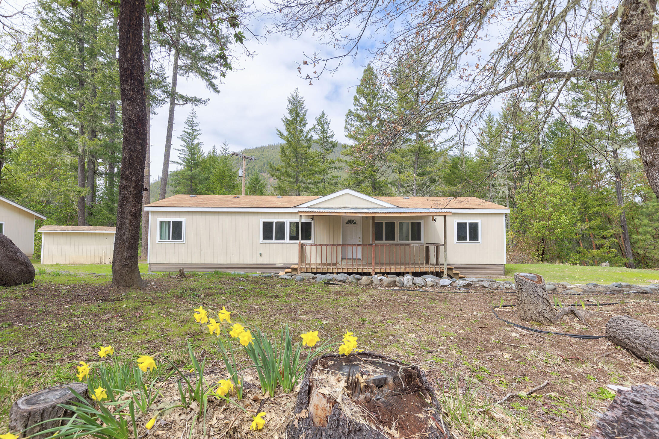 Looking for a peaceful retreat? Look no further than this house nestled on 16.28 acres of land, offering a quiet & very private setting. This all-electric home features 1400 square feet of living space, complete with an extra large, 2 car, 30 x 24 garage with a workshop area - perfect for any DIY enthusiast. Built in 1996, the house has double pane vinyl windows, laminate countertops, and ceiling fans in the dining area and master bedroom. The guest bath has been completely remodeled and the house features all new flooring throughout, making it move-in ready. You'll love the convenience of the laundry in the kitchen area and the front porch, ideal for relaxing with your morning coffee. The large well house offers a storage area and the property's Woodlot Resource zoning provides a range of possibilities. With all new exterior paint on all the buildings & a dishwasher and range included, this home is ready for you to make it yours. Water rights dated 1928. Don't miss out on this gem!