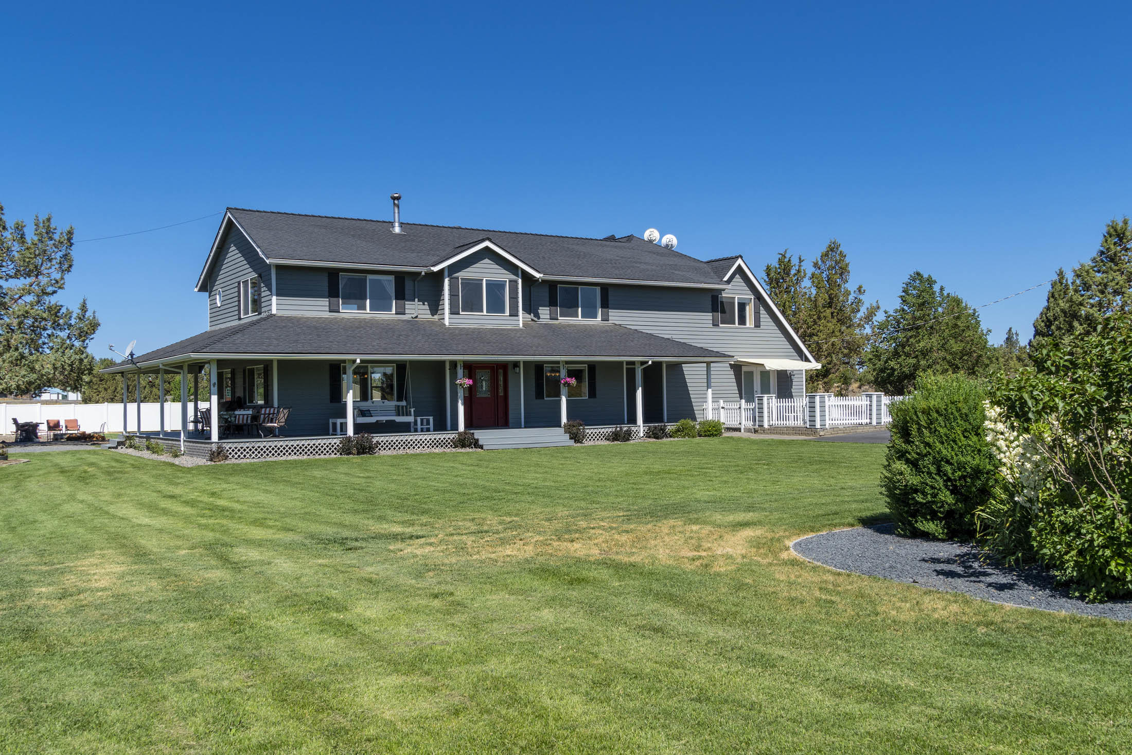 Enjoy this multi-generational country home that has something for everyone!  At 3,964 sq feet, this farmhouse is divided into 3 potential and distinct living spaces.  The main house hosts two master suites (one is currently designed as a self-contained studio apartment), a large multi-purpose room for homeschooling and family game time, and a bonus loft perfect for a work-from-home office.   The additional two BR mother-in-law suite/Airbnb vacation rental offers a full kitchen, full BA, W/D, private entrance, and amazing views of the Cascade Range. This seven- acre property boasts a fully landscaped park-like setting, including 5 acres of automated underground irrigation.  Oversized double 2-car garages, large workshop, and RV/Pole Barn guarantee extensive storage for you and your extended family and all their toys.  Finish your day with a glass of wine on either the wrap-around porch or the upstairs deck while you bask in the high desert sunsets. Welcome home!