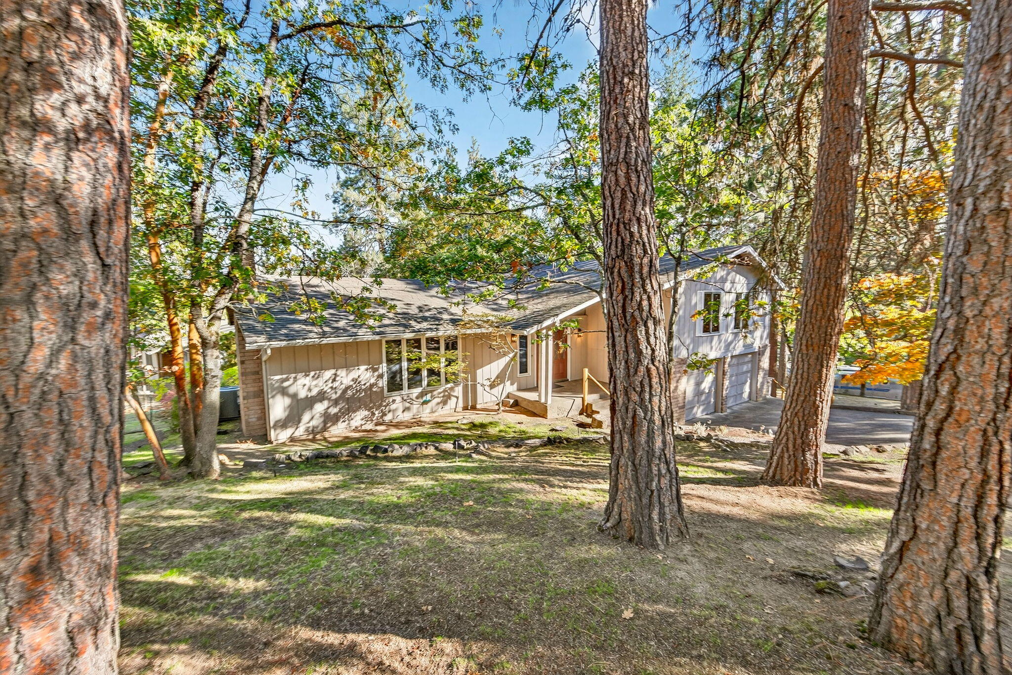 Wonderful mid-century modern home with views in a quiet, peaceful location above SOU and close to an extensive trail network. With many original details, this home has been well-cared for and offers a terrific floor plan and vaulted ceilings. The living room has a wood fireplace and picture windows, creating a warm and inviting place to gather. The kitchen has a lovely breakfast nook with bay windows that offer expansive mountain views. Indoor/outdoor living is a breeze with a spacious, newly rebuilt deck off the family room. Downstairs is an office, media room, and laundry room, allowing for a great getaway space. Upstairs are three bedrooms, including the primary suite with a walk-in closet, an ensuite bath, and sliding doors to a private deck with views. There are many new light fixtures and ceiling fans. All of this and just minutes to downtown Ashland, shopping, and the trails of South Ashland. This is truly a terrific opportunity to live the Ashland lifestyle.