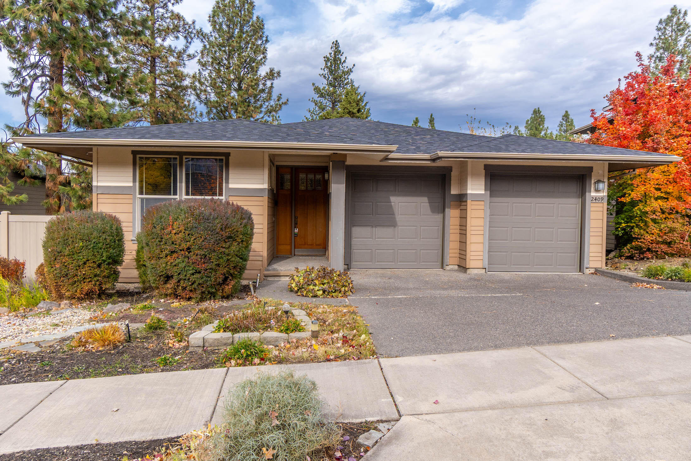 Desirable location near Northwest Crossing, schools, parks, and trails! This 3,105 sq.ft. home offers 3 bedrooms + office/flex space, 3.5 baths, and two primary suites—ideal for multigenerational living or guest privacy. Main level features tile floors, open great room, and kitchen with granite counters & island with breakfast bar. The main-level primary suite has a French door to the deck, double vanities, heated tile floors, large walk-in tiled shower w/dual shower heads, and walk-in closet. The lower level offers a bonus room with laminate floors, pellet stove to keep it cozy on cool evenings, built-in speaker system, French doors to multi-level deck, and a second primary suite with soaker tub, dual vanities, tile counters & separate shower. Washer & dryer hookups on each level, central vac, & all closets feature built-in systems. Low-maintenance decks, paver patio, hot tub, fenced yard, wooded setting, water feature. Workspace/hobby rm on lower level,  2-car garage. New roof 2024