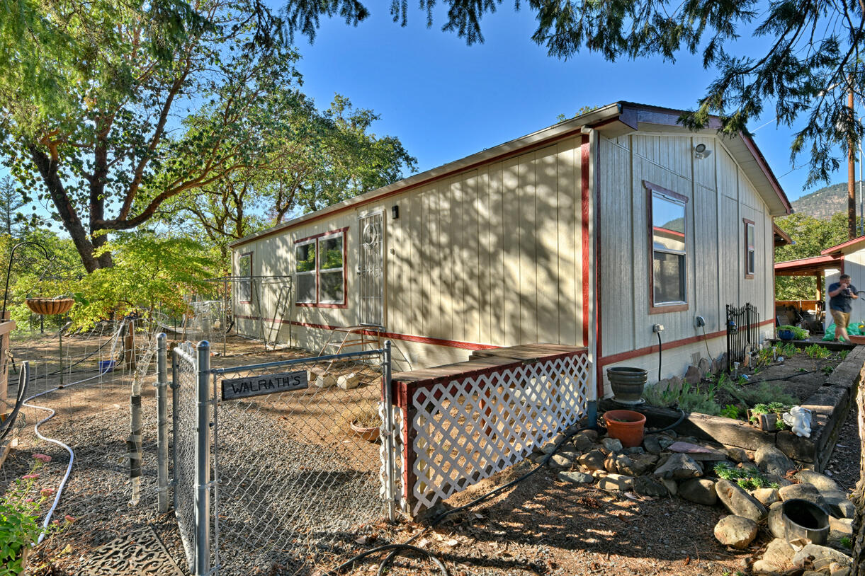 Peaceful country living on five serene acres with Jump Off Joe Creek meandering through the lower portion of the property. The home features vaulted ceilings, abundant natural light, and beautifully updated bedrooms and bathrooms that balance rustic charm with modern comfort. Enjoy a drip-irrigated garden space, greenhouse, and established apple and plum trees. The property includes a 24' x 24' heated detached garage, 12' x 21' Quonset hut, 16' x 12' shed, 8' x 6' pump house with hand pump and storage, plus a shipping container for additional utility. Plenty of room for RV parking, tools, and equipment—offering endless versatility for hobbies or projects. Tools and equipment will be removed by close of escrow. Please only approach property with a scheduled appointment.