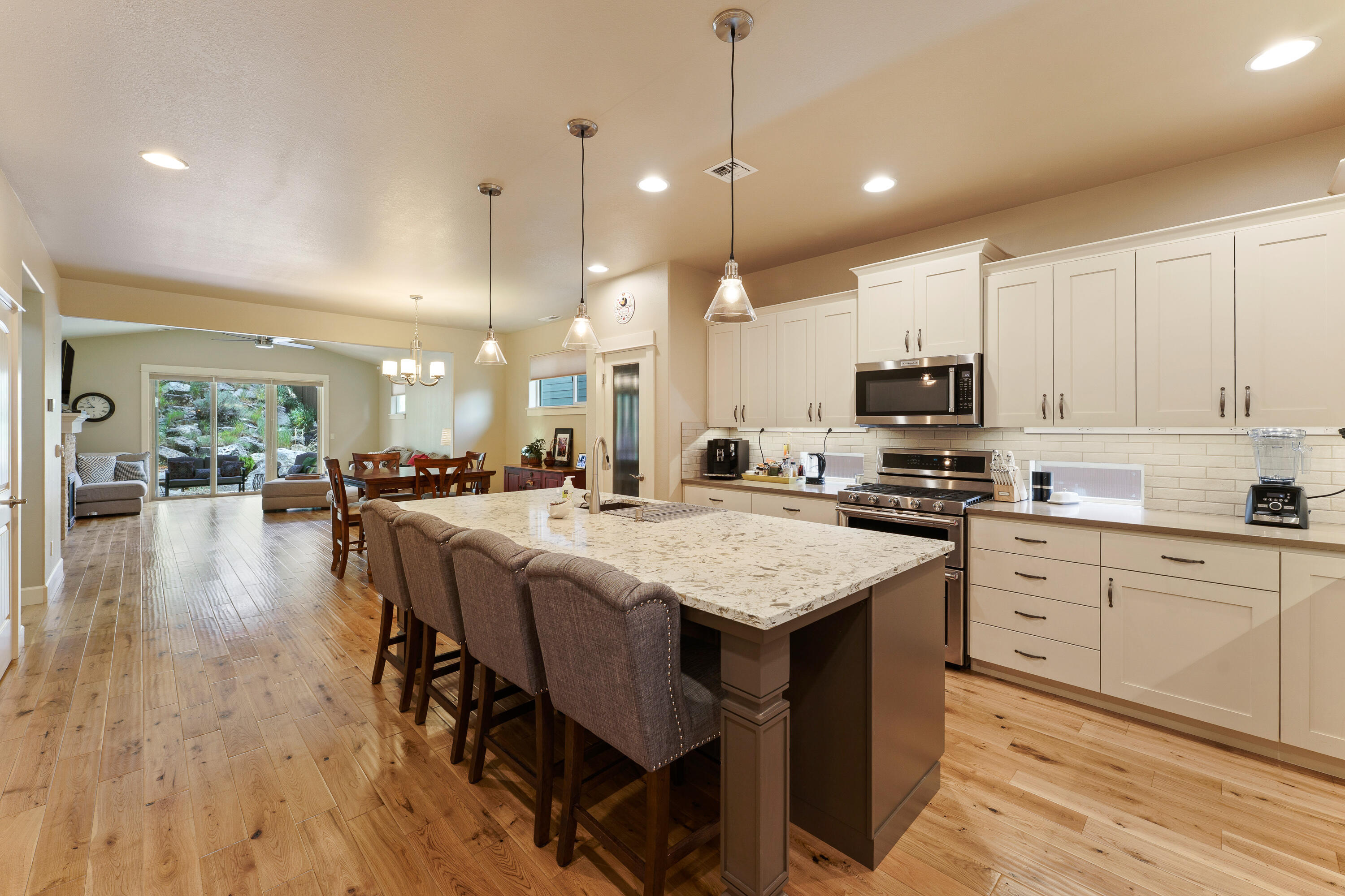 Gorgeous single-level home that lives like new, filled with natural light and quality finishes. Located in the desirable NE Bend neighborhood of Horizon Ridge, this home features energy-efficient construction, hardwood floors, and slab granite countertops. Vaulted ceilings in the living room and primary bedroom add to the open, airy feel. The spacious primary suite includes a luxurious bath with a custom, fully tiled walk-in shower. Enjoy low-maintenance landscaping, upgraded window coverings, gutters, and central A/C. Just a short distance from 36-acre Rockridge Park with a 9-hole disc golf course, playgrounds, and walking trails—this home offers comfort, style, and an exceptional location.