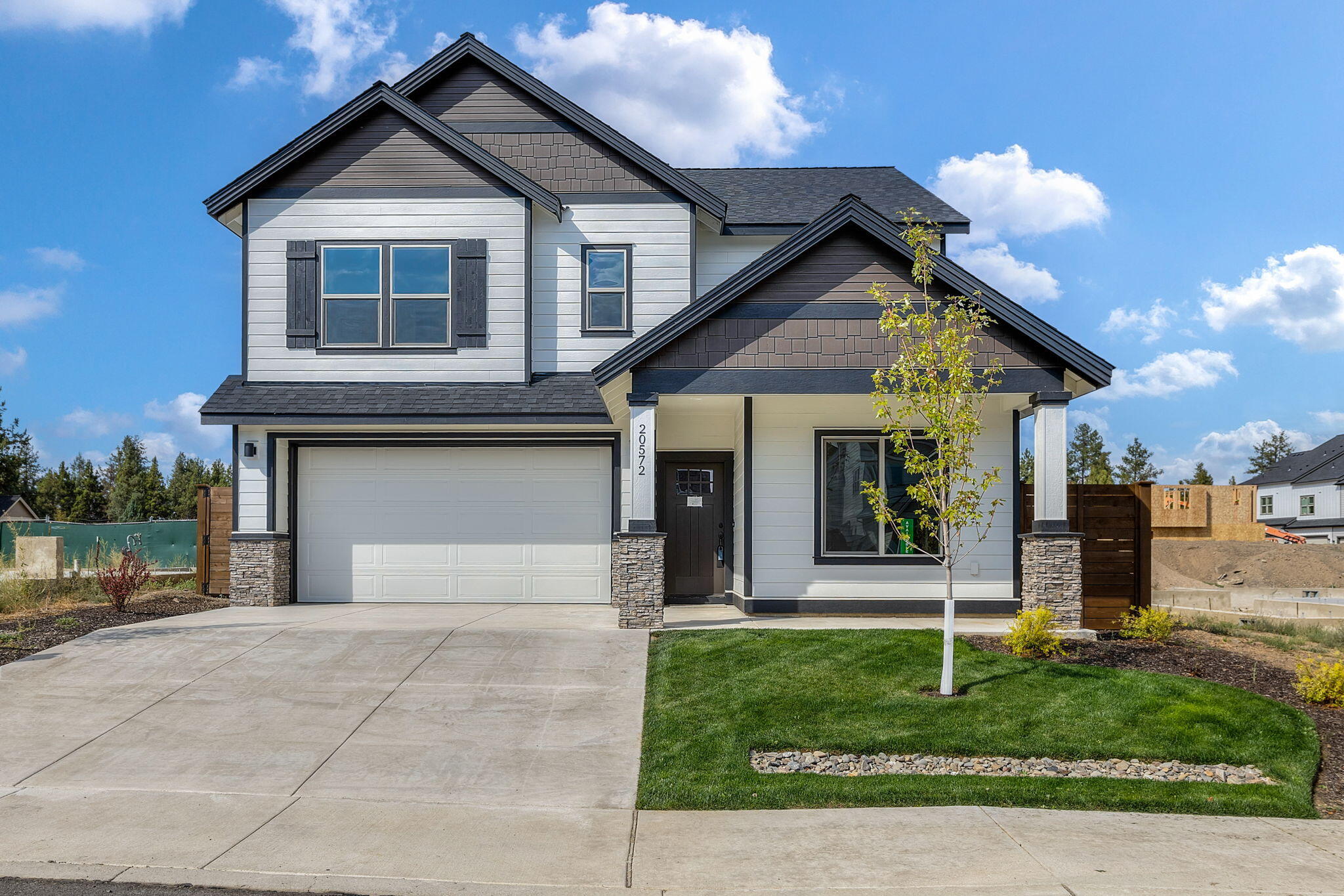 Private Financing Available! 5% interest rate to eligible Buyers. Move in Ready! The Grant- Ideal 4 bedroom floorplan with 1 bedroom and 1 full bath on main level. Entertain in the open kitchen w/ full backsplash, and quartz countertop island facing a beautiful warm & inviting stone surround fireplace with wood mantel. Impressive primary suite offers slider with veranda, vaulted ceiling, stylish soaking tub, full tile shower and large walk in closet. Feel like getting outside? Enjoy over 6 acres of forested park with walking trails connected to a community pool.