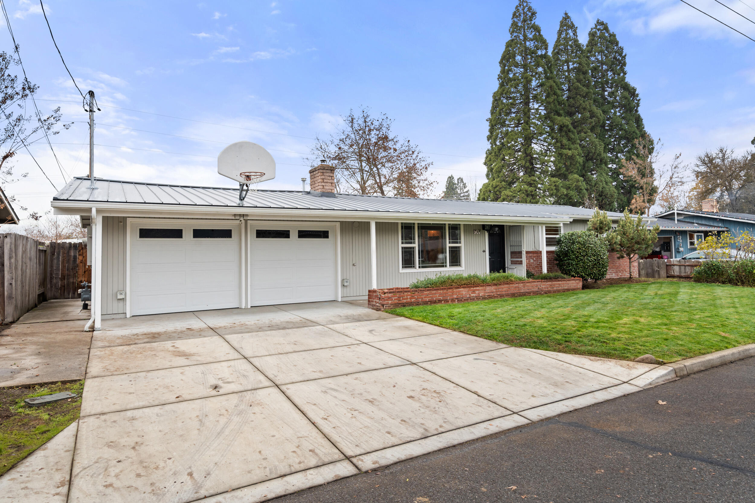 Renovated and move-in ready! This updated single-level home features newer laminate flooring throughout, an updated  kitchen with Corian countertops, double ovens and beautiful cabinetry,and both a living and family room for flexible living. With 3 bedrooms, 2 full baths, and an indoor laundry room, the layout is comfortable and functional. The primary suite stands out with a tiled steam shower and jetted tub for a spa-like feel. Outside, enjoy a huge Trex deck, an oversized yard, and a 2024 metal roof for long-term peace of mind. The backyard includes a powered shop, storage shed and the attached two-car garage offers multiple EV charging points and a newer electrical panel —a rare find. Updated, spacious, and set on a generous lot, this home blends modern comfort with practical extras you don't often see at this price point.