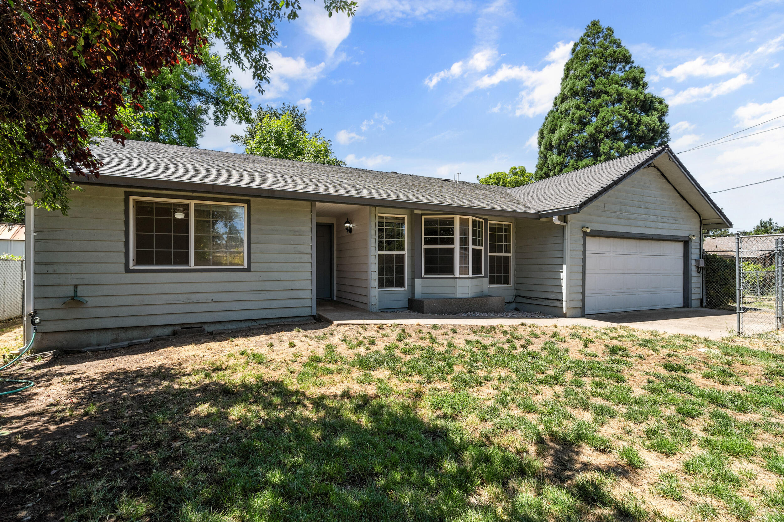 Opportunity awaits new owners needing space and flexibility! Located in the desirable Oak Grove school district, this home sits on a large, private lot with two fenced yards—perfect for pets. Plenty of room for RVs, boats, and extra parking. Inside, you'll find a newer high-efficiency gas furnace & A/C, a cozy gas fireplace and a versatile layout including a second living room that could be a 4th bedroom. A 200 sf garage conversion has served as a playroom, guest space, or storage. Possible ADU (up to 1,269 sf—buyer to verify) offers great multi-generational living or rental income potential. Just 3 minutes to South Medford High. Come see all this home has to offer!