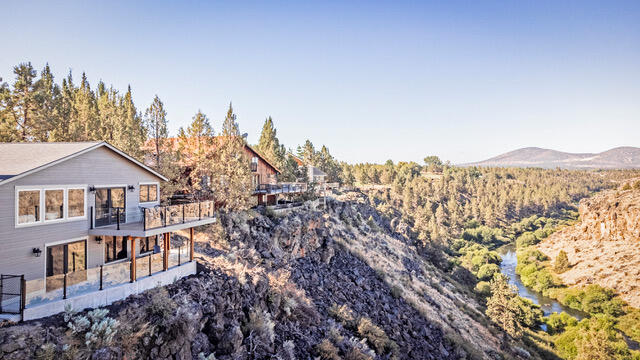Once in a lifetime opportunity to own a custom home with breathtaking views of the Cascade Mountains, canyon, and Deschutes River frontage. This stunning house sits across from miles of BLM, has been completely remodeled from top to bottom, inside and out. Enjoy waking up in the spacious primary bedroom, which encompasses the entire lower level, to a Golden Eagle's nest perched across the river or enjoy the river access that comes with this home on one of the 360 days of sunshine that Central Oregon offers. With 1803 square feet of luxurious living, a second primary bedroom, third bedroom and/or office, all new windows, heating and cooling system, doors, siding, decking, copper coated railing, and wired for a hot tub.. Inside, you will find a new propane fireplace, granite counters, farmhouse sinks, stainless steel appliance, hickory flooring throughout, and maximized lighting. This property offers a dog run, RV hookup, and 1.28 acres with .80 of flood irrigation