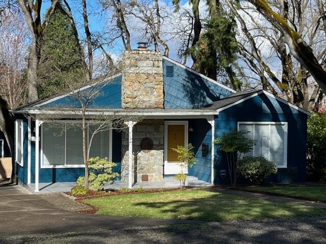 Don't miss this remarkable single-level home in beautiful old East Medford! Surrounded by mature oak trees, this unique bungalow has endless natural light, original hardwood floors, two sizable bedrooms w/original built-in drawers & closets, A recently remodeled bathroom w/a luxurious soaking tub & twin sinks. The front door opens into a large main room with a wood-burning fireplace & a half-wall that peeks into the kitchen where you find attractive granite countertops, a breakfast bar, stacked washer/dryer combo, shaker cabinets w/ storage, and french doors leading out to the back deck (w/a tree growing through it!). The spacious composite and cedar deck has stairs that lead into the backyard + a rare find: an additional living space with its own entrance, carport, newly restored brick patio, & bath with a standing shower. Use this space as a guest house, mother-in-law, home office, 3rd bedroom, whatever you want!  Enchanting and full of character, this is a must-tour property.
