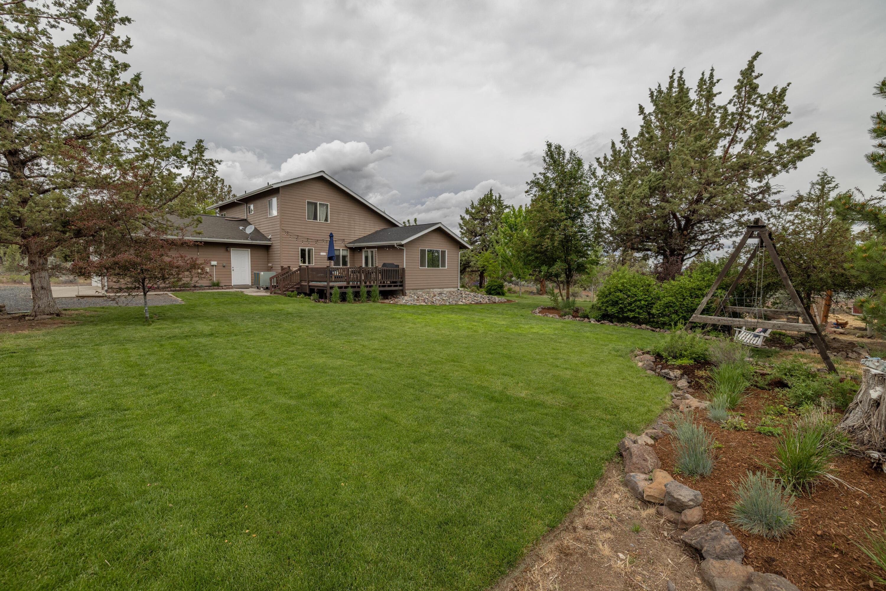 Beautiful custom home (3 Bed, 2 1/2 Bath) on acreage in desirable Chaparral Estates within a stone's throw of Deschutes River! Home is complete with primary bedroom suite on 1st floor featuring hobby/school room on the same level; offer a lot of privacy situated right in the middle of this 1.54 Acre corner lot.  The dining & great room feature an expansive vault ceiling along with a 1st floor laundry room. The residence boasts a 2-car attached garage + a very large 40' x 24' Detached Shop w/ large project loft area for all the toys & tools - can store RV's! Newer Fence around entirety of the property, underground sprinkler system, extensive landscaping, & large rear deck that looks out to the yard, garden, & chicken coop. One block to BLM & River access right between Bend & Redmond... come take a look and make it yours today!