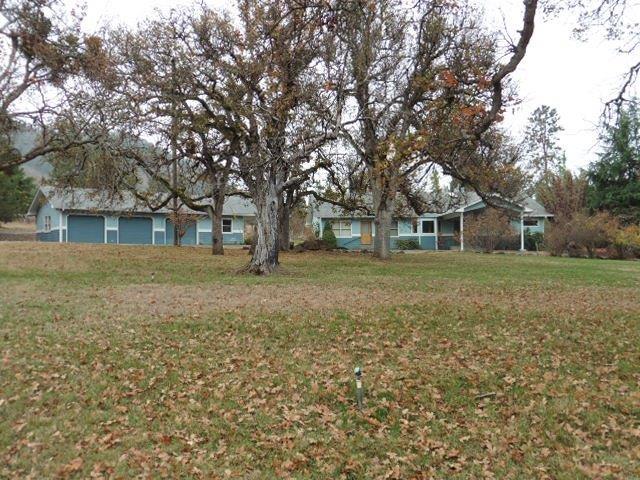 Beautiful setting with awesome oak trees and views of the mountains and vineyard. Located in Ruch and sits back away from the road on quiet acreage. Property offers lots of flat land and a detached garage shop with 3 bays and a car port. Inside offers a light filled living room with a wall of windows to take in your surroundings, dining area with harwood floors and a large, very usable kitchen. Split fllor plan offers a large master suite on one end with tons of storage and a large master bathroom with jetted tub and shower. The other end of the home offers 3 more bedrooms and a full bathroom with a good sized laundry room. Great home in a great setting. A true Southern Oregon Dream!