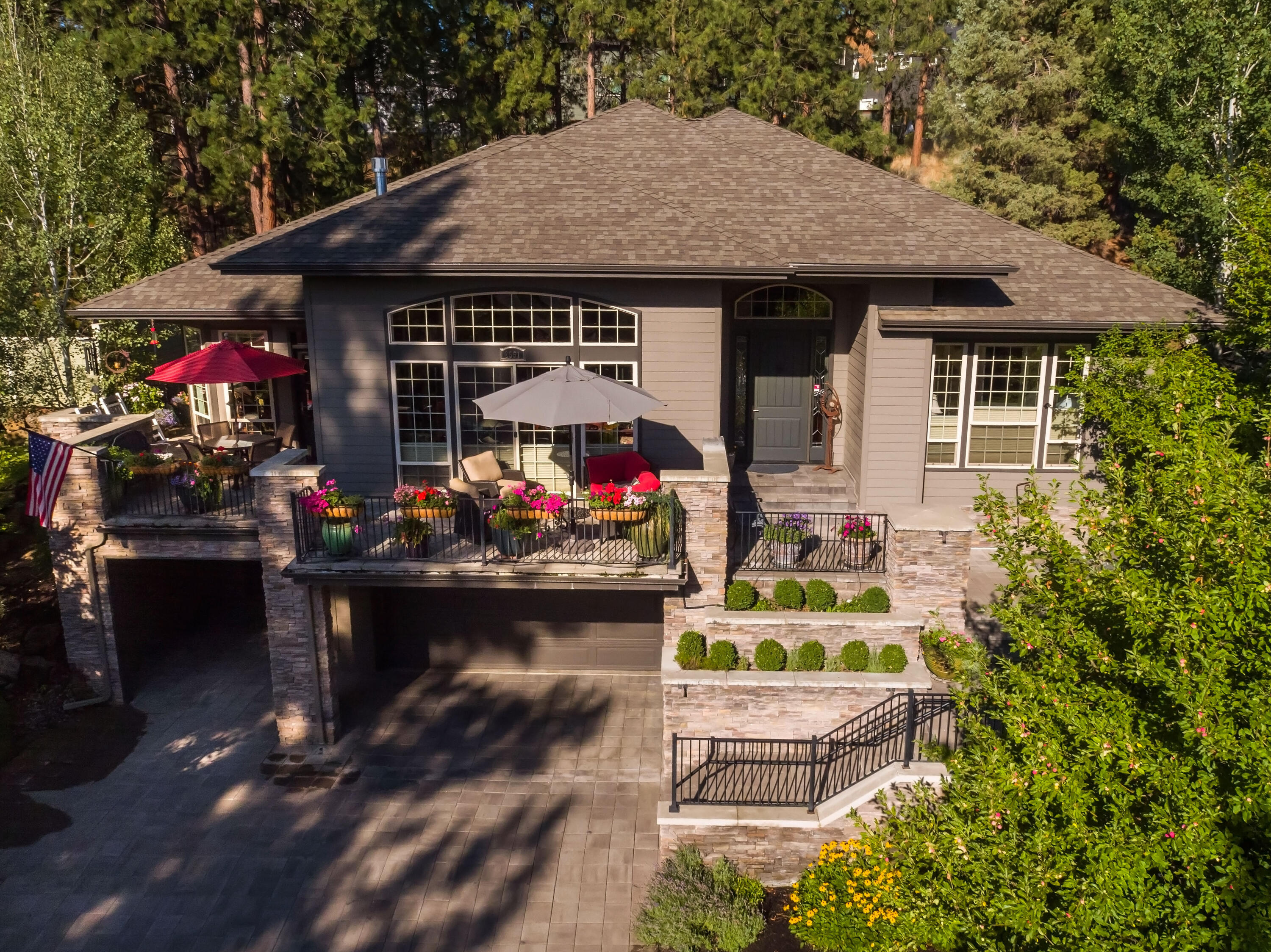 Offers welcome. Set on an elevated private lot in Shevlin Ridge where tall pine trees and outdoor living abound, this spacious and unique home was beautifully remodeled in 2010 to add an additional 500 sq ft of living space. Here, an open layout, soaring ceilings and natural light create an ideal retreat into privacy and elegance, complete with brazilian cherry floors, coffered underlit ceilings and wrap-around paver patio. An open kitchen for entertaining or cooking for a crowd, with an oversized island and luxury appliances. Cozy up in the great room by the gas fireplace and custom hearth, or retreat to the family room with access to the private back patio. On the main floor, the sun-lit primary suite offers a double vanity, claw-foot tub and tile shower, large walk-in closet and two additional bedrooms with jack & jill bath. A lower level ensuite bedroom, media room, or office adds even more space to unwind. The three car heated garage and carport includes room for a workshop.
