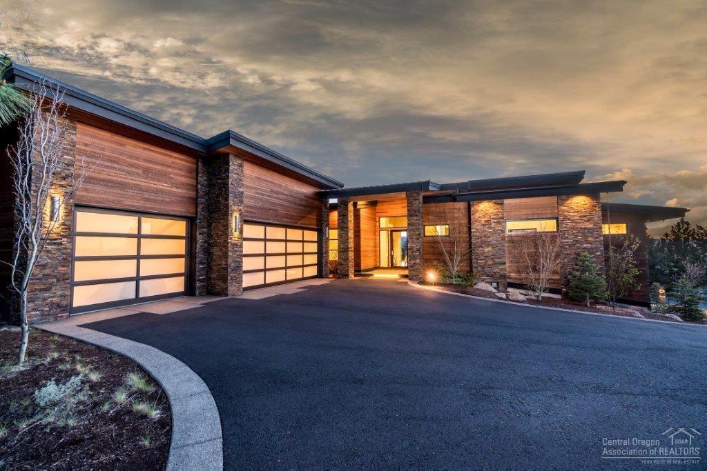 Stunning Awbrey Butte contemporary home w/CASCADE VIEWS. Great room w/modern FP, sliding glass wall opens to deck w/gas fire pit. Kitchen w/Caesarstone, custom cabinets, Wolf oven, Dacor 6 burner stove, dual sinks & raised eating bar. Dining area w/wine bar. Master suite on main, FP, jetted tub & steam shower. Downstairs w/2nd master, office w/built-ins, media room w/wet bar, fitness room. Energy efficient w/radiant heat, AC, filtered water system. Covered patio and Xeriscape landscaping. 3 car garage.