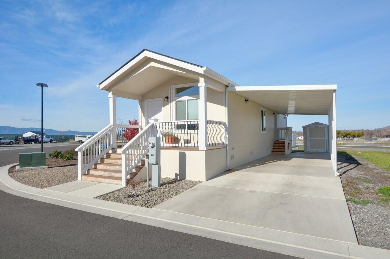 This beautiful and modern single-wide, 2-bedroom, 1-bath home—built in 2024—is ideally situated between Phoenix and Medford, close to shopping, restaurants, schools, and hospitals. Inside, you'll enjoy bright living areas with large windows that fill the space with natural light, sleek cabinetry, contemporary vinyl flooring throughout, and an open-concept layout that feels spacious and inviting. The home also includes a washer and dryer, a covered carport, a storage shed, and a covered front porch, perfect for relaxing outdoors. With stunning mountain views and a low-maintenance yard, this home offers easy, comfortable living. Located right next to the community park, in an all-ages, pet-friendly community and is move-in ready! Schedule a tour today!