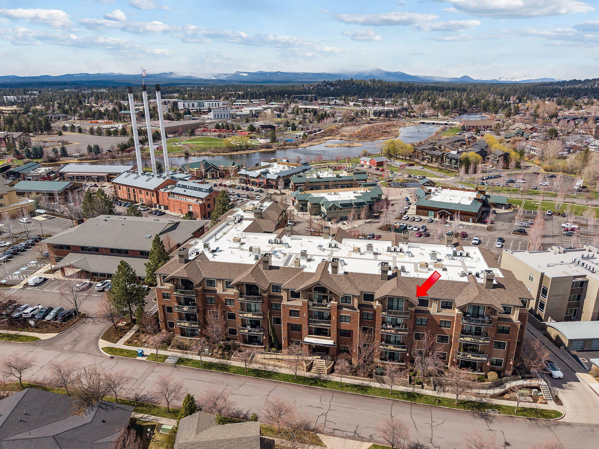 Experience refined living in Bend's Old Mill District with this elegant 4th floor condo at The Plaza. Featuring soaring cathedral ceilings and a private balcony, it blends sophistication with convenience just steps from premier dining, shopping, and riverfront trails. The open great room showcases large windows, a gas fireplace, and territorial views. The chef's kitchen offers granite counters, stainless appliances, island seating, and a large walk-in pantry. Two spacious primary suites provide privacy—one includes dual vanities, a soaking tub, tiled shower, and walk-in closet, and the second primary suite features dual vanities, shower and walk-in closet and could also be ideal as a home office. Plaza amenities include a fitness center, 1,500 SF entertainment room with full kitchen and fireplace, outdoor patio with fire pit, and secure garage with 2 deeded parking spaces plus storage. Enjoy zero-maintenance, single level living in a prime Bend location!