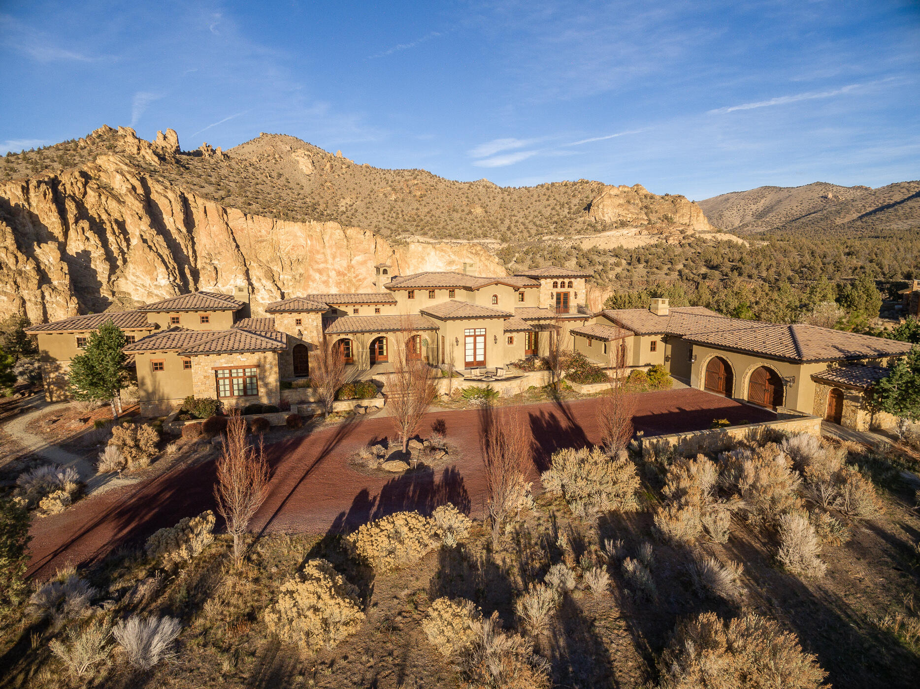 This Ranch at the Canyons home is a timeless masterpiece. Stunning views from every window capture Smith Rock, the Crooked River and Cascade Mountains. The balance of stone & wood, light granite & dark cabinetry, graceful archways & masculine fireplaces has created a welcoming ambiance. The living room features an elegant corner bar & double fireplace to the kitchen, a gathering place with plentiful seating, Wolf range, 3 ovens, SubZero fridge, 2 sinks & oversized island. The primary suite has spectacular views & luxury bath. A junior suite enjoys its own courtyard; 2 en suite bedrooms with patio access are at the far end of the home. The office is at the pinnacle with mountain and river views from every angle. Relax & entertain in the upscale bonus room. This prestigious, gated community has 1700 acres for 46 landholdings, a clubhouse, event venue, equestrian center, trails, ponds, 2 miles of river frontage & the serenity of nature.