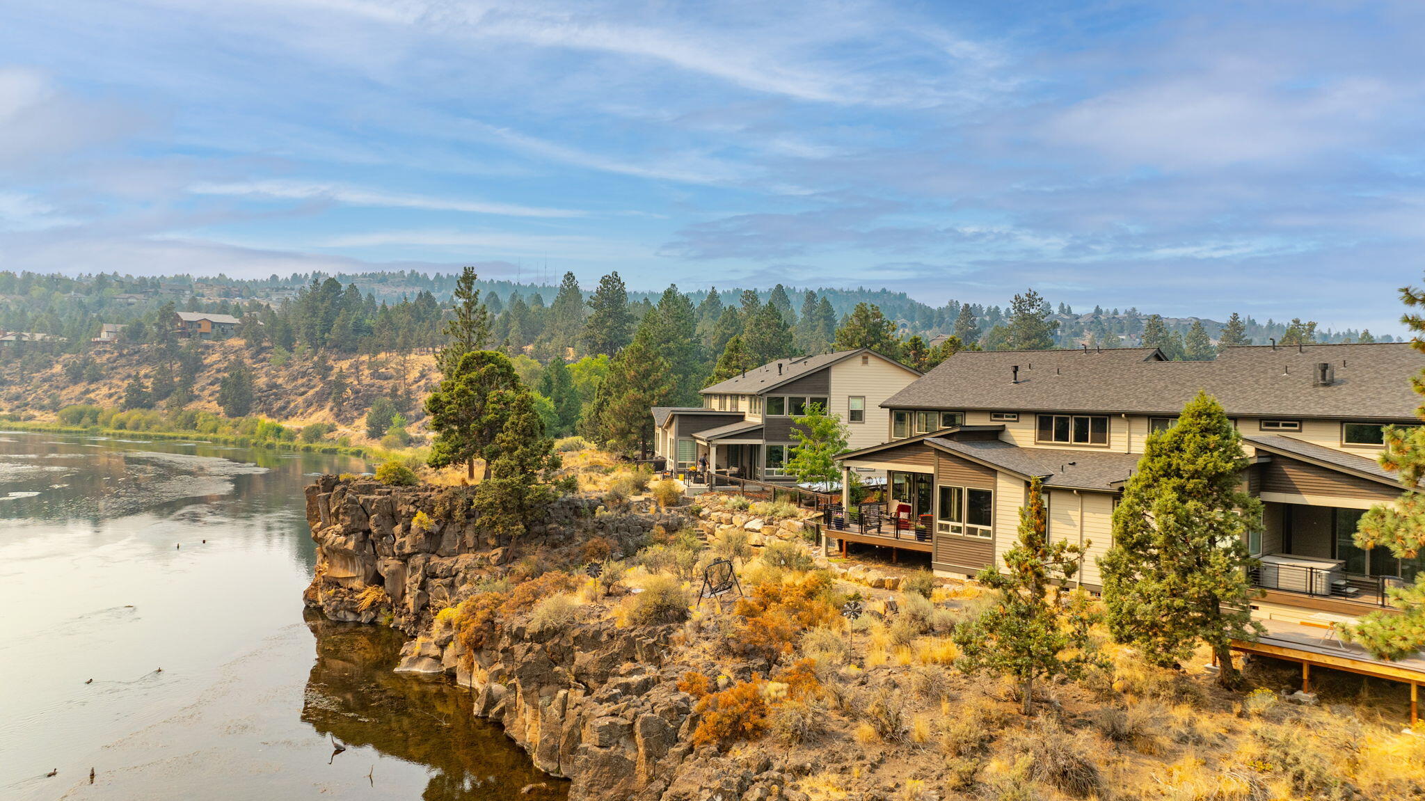 Situated directly on the Deschutes River commanding a premium river view, & next to River's Edge Golf course, sits this unique townhome in the gated community of The Pointe at River's Edge. This townhome boasts distinctive finishes and top-of-the-line upgrades that set it apart from the rest. From high-end Hubbardton Forge lighting, Kinetico whole house water system, remote blinds, an outdoor kitchen, to modern fixtures and appliances, every detail has been carefully selected to create a luxurious living experience. This home includes an entertaining kitchen and dining area, 2-story great room with fireplace, main level primary w/ soaking tub & w/in closet, upstairs guest suite, additional bedroom & loft area with wet bar, mud room/laundry, garage with 220 plug-in, and an abundance of California Closets built-ins throughout. This is a rare opportunity to own a home on the Deschutes with private neighborhood access! Close to all amenities, Deschutes River Trail, and outdoor adventures.