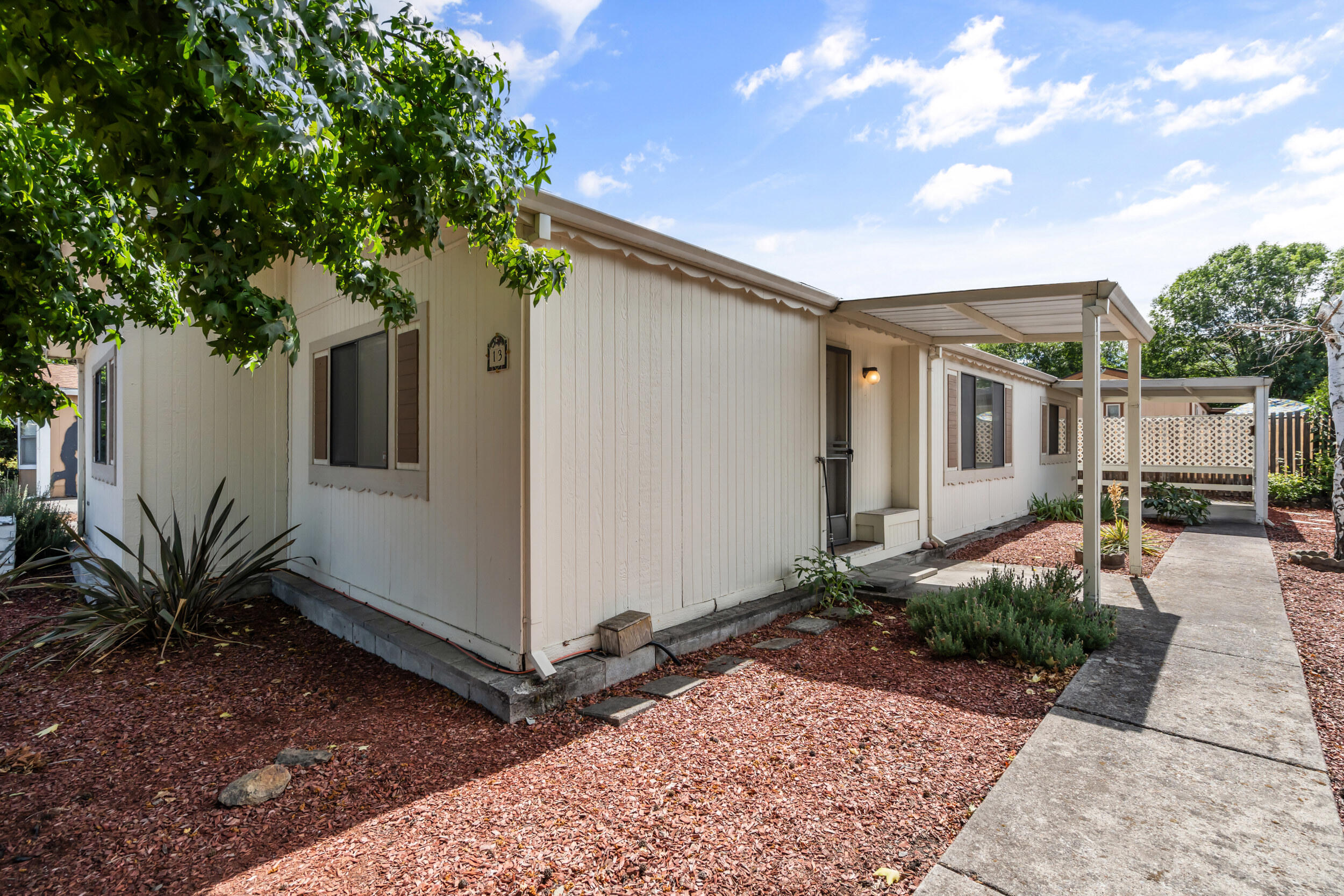 PRICED TO SELL AT GREAT PRICE!  Move-In Ready Home in 55+ Rogue Valley Mobile South Park.  3-bedroom, 2-bathroom home w/ comfort, convenience, & charm all in great location! Bright & inviting living room w/ large picture window that fills space w/ light. Kitchen w/ lots of counter space & cabinetry & skylight. Primary suite w/ double closets,  private bath w/ walk-in shower & skylight. Two additional generously sized bedrooms & full guest bath w/ tub/shower provide plenty of room for family or guests. Enjoy the convenience of a laundry room w/ built-in cabinetry & access to covered carport that's perfect for unloading groceries w/ ease. Outside, the fenced yard includes raised garden bed, ideal for growing your own veggies, or flowers. Minutes from restaurants, shopping, Golf Course, & Asante Rogue Medical Center.  Enjoy the pool table, full kitchen & seasonal pool. *Space rent includes water, sewer, trash, common area.