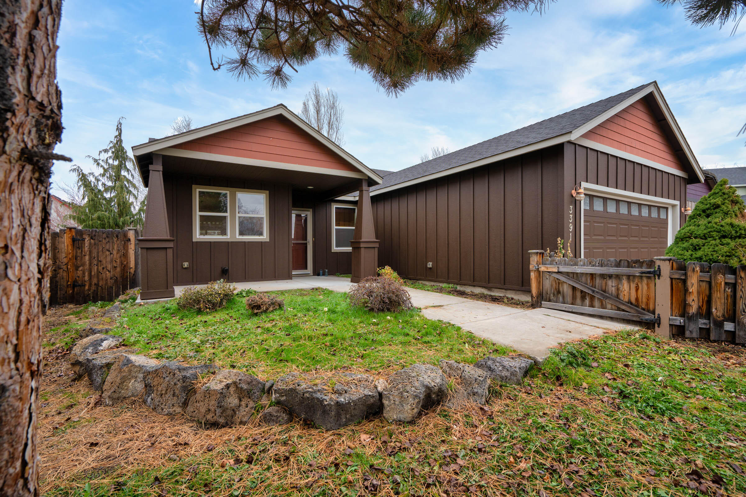 Tucked within a quiet cul-de-sac, this charming single-level home welcomes you with a sweet picket fence, a country garden, freshly painted exterior, and a covered front porch perfect for morning coffee. Inside, the thoughtful layout features fresh paint, cozy gas fireplace, bright living spaces, and a functional kitchen with a gas range and included appliances. The primary suite offers double vanity and ample storage, while the utility room adds everyday convenience. Step out back into a covered deck overlooking a fully fenced yard with a darling garden shed—ideal for hobbies or storage. Sprinkler system with timer in front and rear. With forced-air gas heat, a heat pump for year-round comfort, and an easy-care 0.14-acre lot, this 3-bedroom, 2-bath home combines simplicity, warmth, and location in one inviting package.