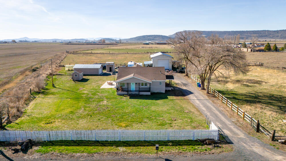 Escape to country living just minutes from town! This tastefully updated farmhouse nestled in a serene setting near the base of Stukel offers the perfect retreat. Situated in the desirable Henley School District this property boasts 4.8 acres of fully fenced land with KID ''A'' water rights. Step inside to discover a home outfitted with newer appliances, including a Carrier furnace & AC that are a couple years old. Outside a huge 42'x30' shop awaits, along with an oversized 2-car garage, 8'x14' shed, 8'x12' greenhouse, pump house & chicken coop. Whether you dream of a hobby farm, a horse property, or simply crave peace & quiet, this property has it all. Don't miss out on the opportunity to make this idyllic retreat your own!