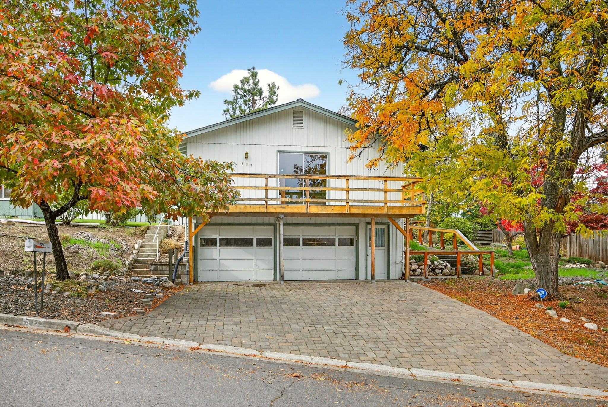 Welcome to 697 Oak Knoll Dr.-a home full of potential and is just a stone's throw away from the Oak Knoll Golf Course. The property is perfect for anyone looking to add their own style and updates. Step into a light-filled interior where all the living spaces are conveniently located on the main floor. The bright and comfortable large living room with a gas fireplace is perfect for relaxing or gathering with friends and family. There's an extra space next to the living room that could easily be set up as an office or creative space with access to the backyard. The long galley kitchen sits just off of the living area. Adjoining the kitchen is a separate lg laundry area and a pantry. Everything flows nicely from one room to the next. The primary bedroom features a walk-in closet and a private deck with lovely views of the mountains and the nearby golf course. Downstairs, you'll find a 2-car garage with extra storage. The exterior has a covered entrance and nice size yard and deck.