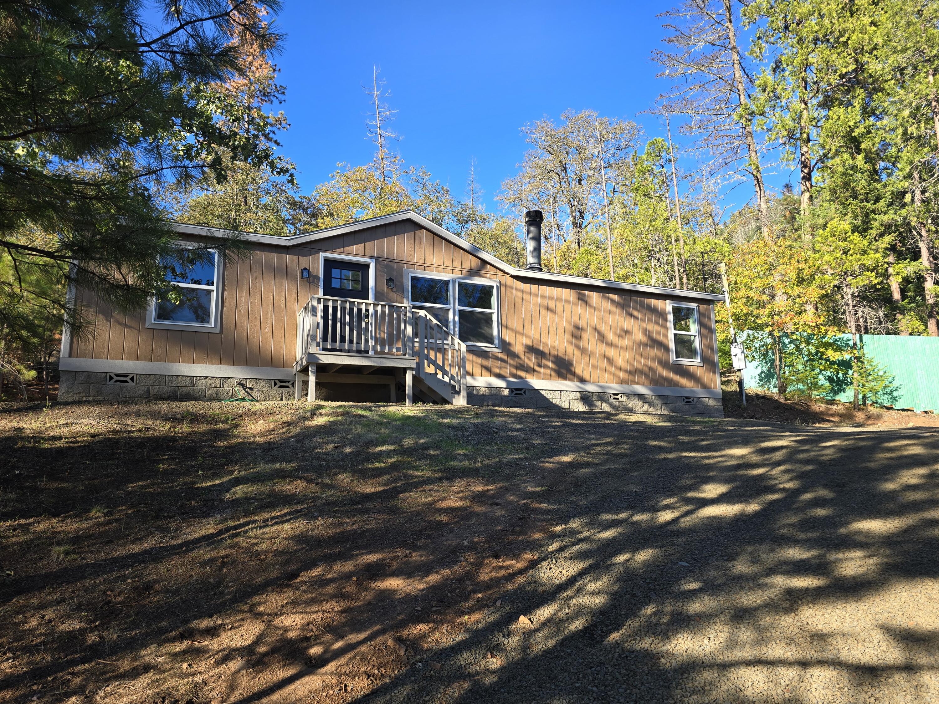 Welcome to a serene mountain retreat in Prospect! Nestled on just over a half-acre minutes away from the Rogue River-Siskiyou National Forest, this beautifully updated 3-bedroom, 2-bath home offers a comfortable and peaceful lifestyle. Bask in the glow of the cozy fireplace, unwind in the soaking tub, and enjoy sweeping forested views from nearly every room. Recent upgrades include some new windows and new flooring throughout—so this home is truly move-in ready. Located just steps away from the tranquil waters of Lost Creek Lake, you'll enjoy easy access to boating, fishing, paddleboarding, or simply relaxing lakeside. The nearby trail systems and scenic viewpoints offer abundant outdoor recreation year-round—from hiking to water-falls to winter adventures. This home offers the perfect blend of private, quiet living and access to adventure—whether you're looking for a year-round residence, a vacation haven, or an escape from the hustle and bustle. Come take a tour.