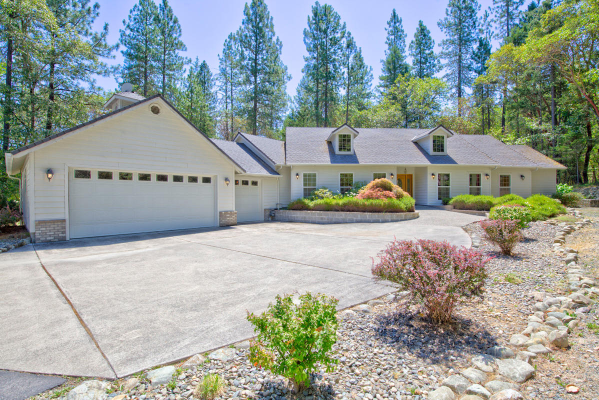 Welcome to this inviting home nestled in the trees, with many amenities. Built in 2001, the covered front porch leads into the great room with gas fireplace and entertainment center, gourmet kitchen with Corian countertops, butcher block center island, gas cooktop, double ovens, warming drawer, microwave, trash compactor, and fine cabinetry. Luxurious master suite with jetted tub and large walk in closet, a den that could be used as a bedroom, split floor plan guest bedroom, main bath and laundry room with generous storage complete this 1 level home on 2.55 acres. The covered back porch is perfect for entertaining with gas for the grill ready to go! Great location near golf course, shopping, hospital & RCC. Oversized attached garage with shelving storage and don't miss the huge shop built in 2009 at just over 2,100 square feet large enough for your RV and boat. Covered parking for 6 or more vehicles providing plenty of space for all of your toys!