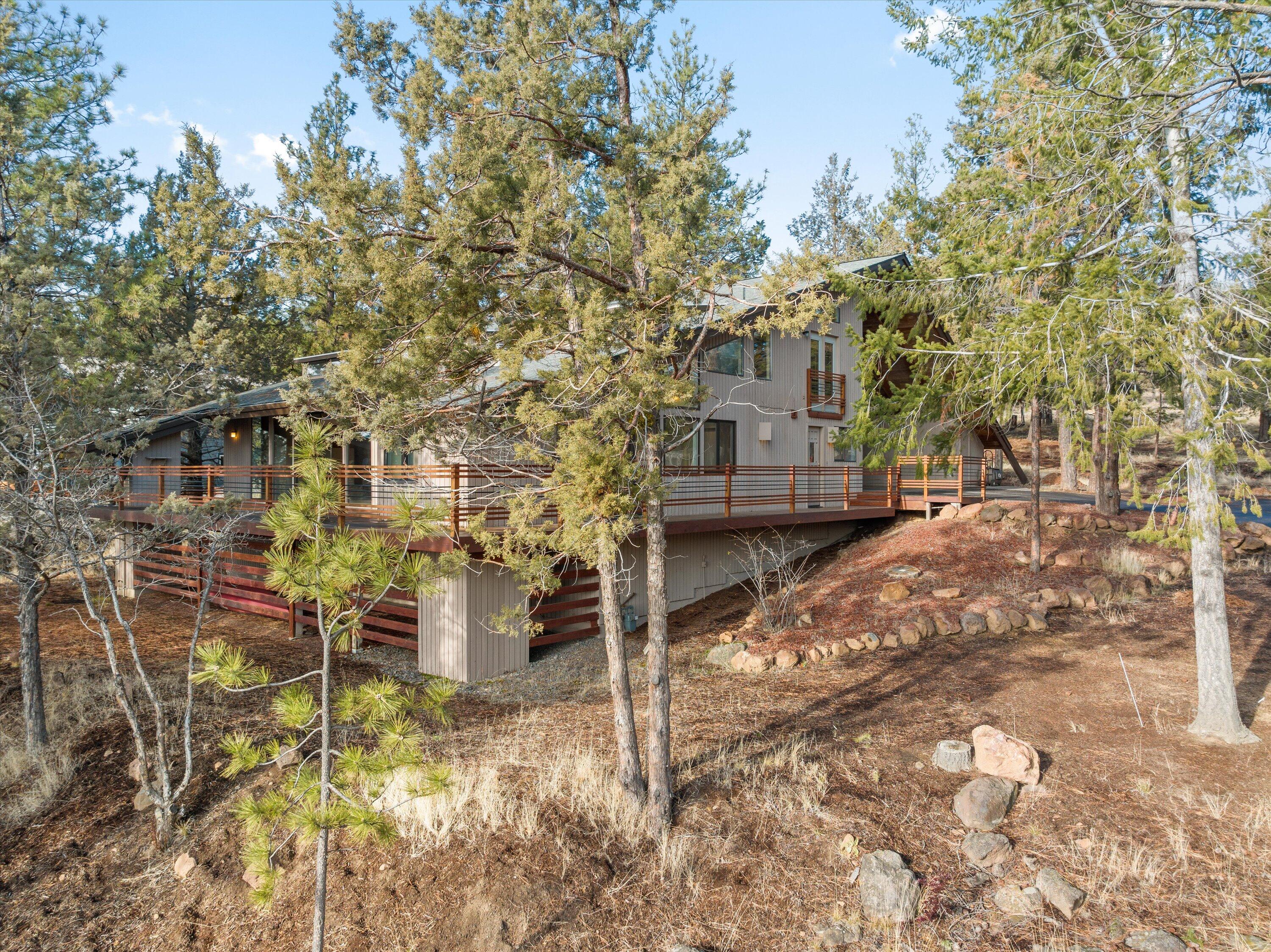 Mid-Century meets Mountain Modern in this enchanting home in the desirable West Hills neighborhood.  A wall of windows with a sliding glass door opens onto the large deck with southern mountain views and views of the city and Old Mill.  Very private .44 acres with room and design plans for a garage with an ADU.  3 separate living spaces including a spacious living room with a gas fireplace, vaulted ceilings and beams, family room/bonus room and/or office, and a bright open 2 story sunroom.  All three bedrooms located upstairs.  Two bedrooms are connected by a shared bath, each with a private office or playroom. Ideal location with easy access to the best Bend has to offer.