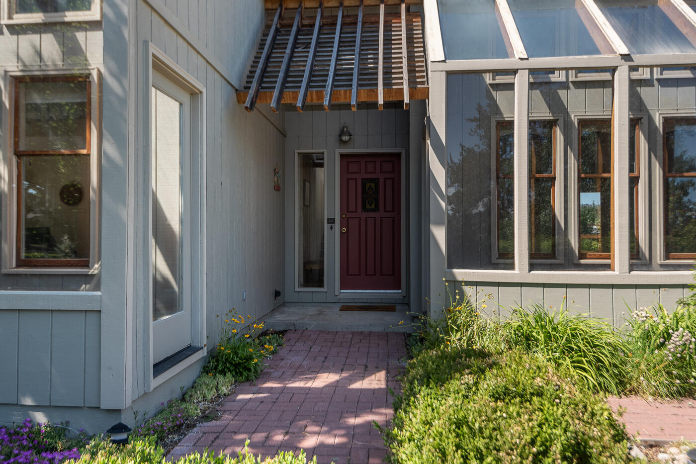 This light filled home has towering walls of windows that face south, huge vaults in the front, hardwood floors, feels light, bright, airy and unique! This passive solar home has flexible living spaces and would work great for families or multigenerational living with a full bath and bedroom on the main level. The parcel backs up to farmland and feels so quiet, private and secluded, making the parcel feel much larger than its size. No neighbors in the backyard! This home feels and lives larger in and out than its size and offers so much peace, privacy and quiet, yet is so close to town. This small acreage lot with irrigation has all of the fun of rural living without all of the work.  Watch the sunrise and sunset from the back deck, or stare at the rolling hills of the valley and acres of green pastures all around! Horse Friendly and great internet too. This fun home won't last long, so call your Realtor today and schedule a showing!