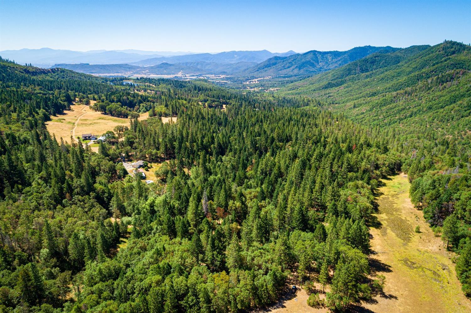 Tired of Neighbors? Choice building site with lots of water!!!! Incredible location completely improved with all infrastructure for building your dream home today! This gorgeous 40 acres of magical woods has interior roads, timber, and natural meadow, with historical cabin and 2nd well. If you are seeking privacy, don't miss this exceptional property with seasonal creeks, artesian well, good septic, paved driveway, completely fenced, solid well-built bridge and an incredible shop building with a strip kitchen & bath. Substantial dog kennel & yard, pretty plantings, berries, fruit trees, & garden. Don't miss this close in country living with Federal lands on two sides, wildlife everywhere, clean air, peace and quiet! There is a 1991 manufactured home with 3 bedrooms & 2 baths to live in while you are building. No others compare - make an appointment today to see this outstanding offering!