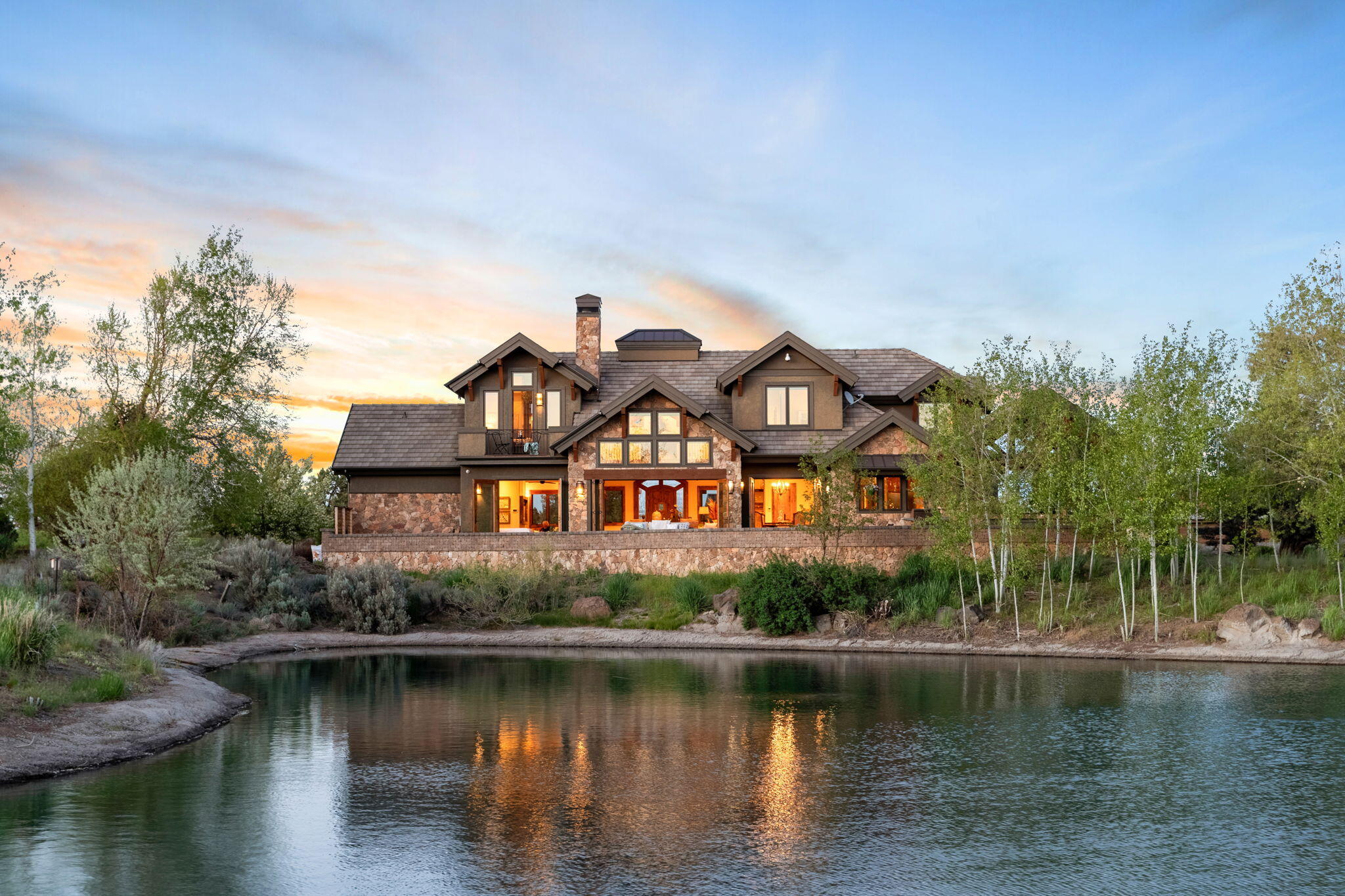 Welcome to Paradise at the coveted Juniper Preserve! This spacious, 4296sf home includes 4 bedroom suites (2 up, 2 down) with 2 additional 1/2 baths. Luxury kitchen with Tiger Maple cabinets, walk-in pantry and Wolf appliances. Enjoy stunning floor to ceiling views of the water and Cascade Mountains from the Great Room with stackable patio doors opening to your backyard oasis. Dining area also opens to the expansive back patio where you'll find the covered full outdoor kitchen - built in BBQ, wine fridge and mini fridge/freezer, dishwasher, side sun shades, hidden pop up TV and sunken fire pit, all overlooking the water and beyond! Another patio entrance adjacent to the hot tub leads to the large primary bedroom and sitting area, bathroom with rain head shower and ample closet. Upstairs suites boast incredible mountain views - one with private balcony! A large bonus room completes the upstairs retreat - don't miss the huge storage space or potential bunk room above the garage!