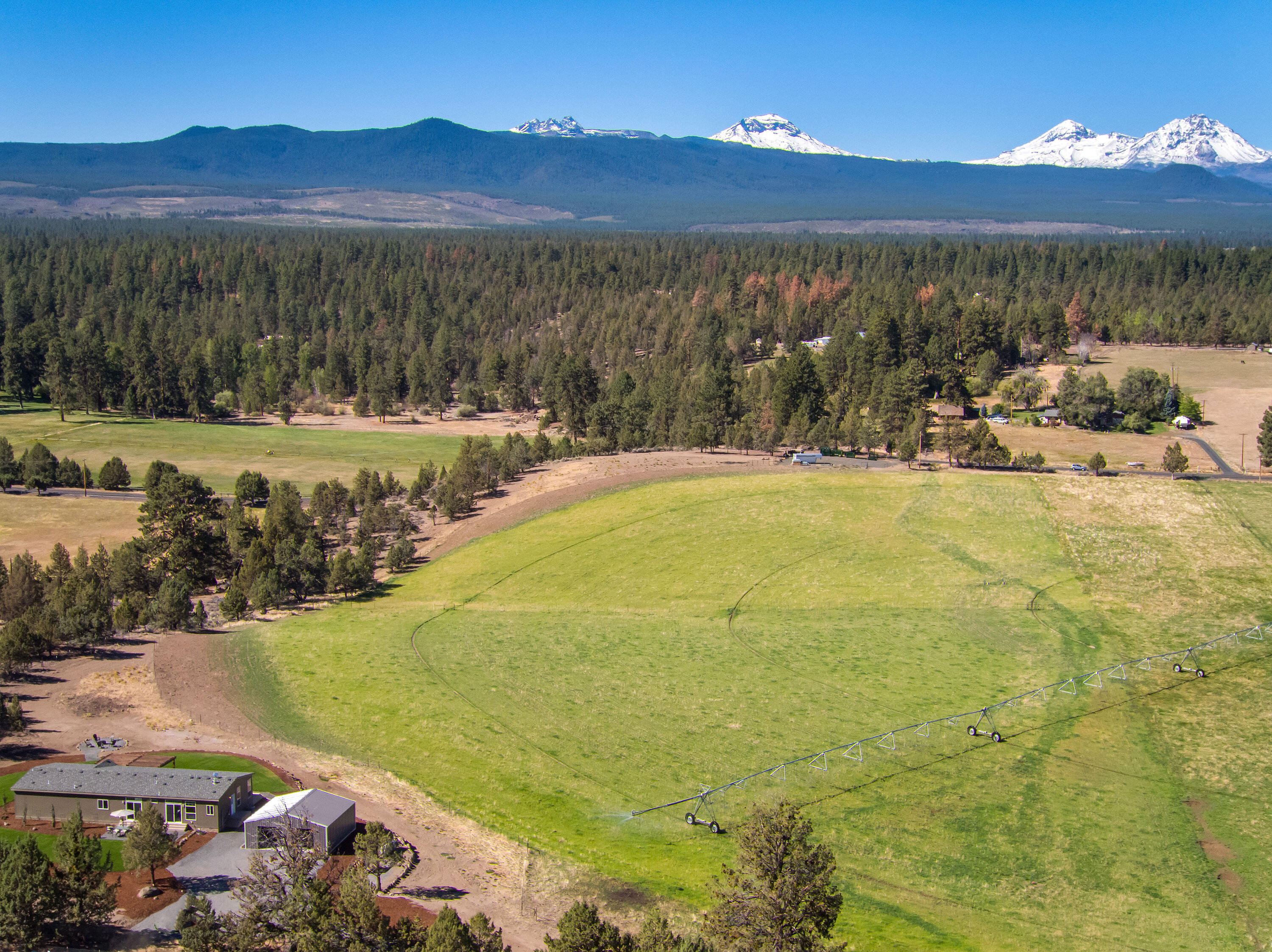 Panoramic Cascade Mountain Views from Tumalo acreage property. Property is 39.04 acres, 3 tax lots, with 33 acres TID water rights irrigated with a pivot. New single level 2400 sq ft home with an open floorplan, 3 bedrooms, 2 bathrooms, office, living room, family room, master suite, utility room, quality finishes throughout and a two car garage. Terrific outdoor living with decks, landscape with sprinkler system, fire pit and stunning views overlooking the green pastures and mountains. Property is fenced, gated, ready for livestock and is close to public land for mountain biking, hiking or riding. This property is ready for any Central Oregon lifestyle!