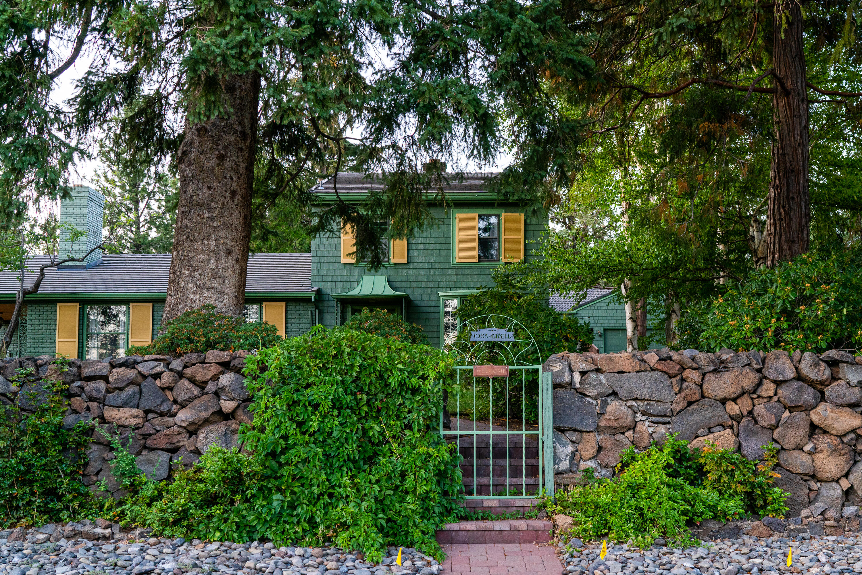 This rare Georgian Colonial home was built by the Shevlin-Hixon Lumber Company in the early 1920's on three city lots totaling .64 of an acre on the majestic southern slope of Awbrey Butte within walking distance to downtown Bend.  Old growth trees and rhododendrons create a sense of privacy and capture the essence of Central Oregon.  This two-story home features four bedrooms, one bath up; and a very large primary suite on the main floor and basement.  A large in-ground pool and hot tub is surrounded by expansive patios and decks creating the perfect amenity to outside living and entertaining.  A four car garage with two double doors can be accessed on Saginaw and Roanoke.  An old stone wall encompasses the estate enhancing the rustic atmosphere.  This home is perfect for the distinguished buyer who enjoys the home's historical significance or for those who see its endless potential for remodeling to bring a classic into the modern era.