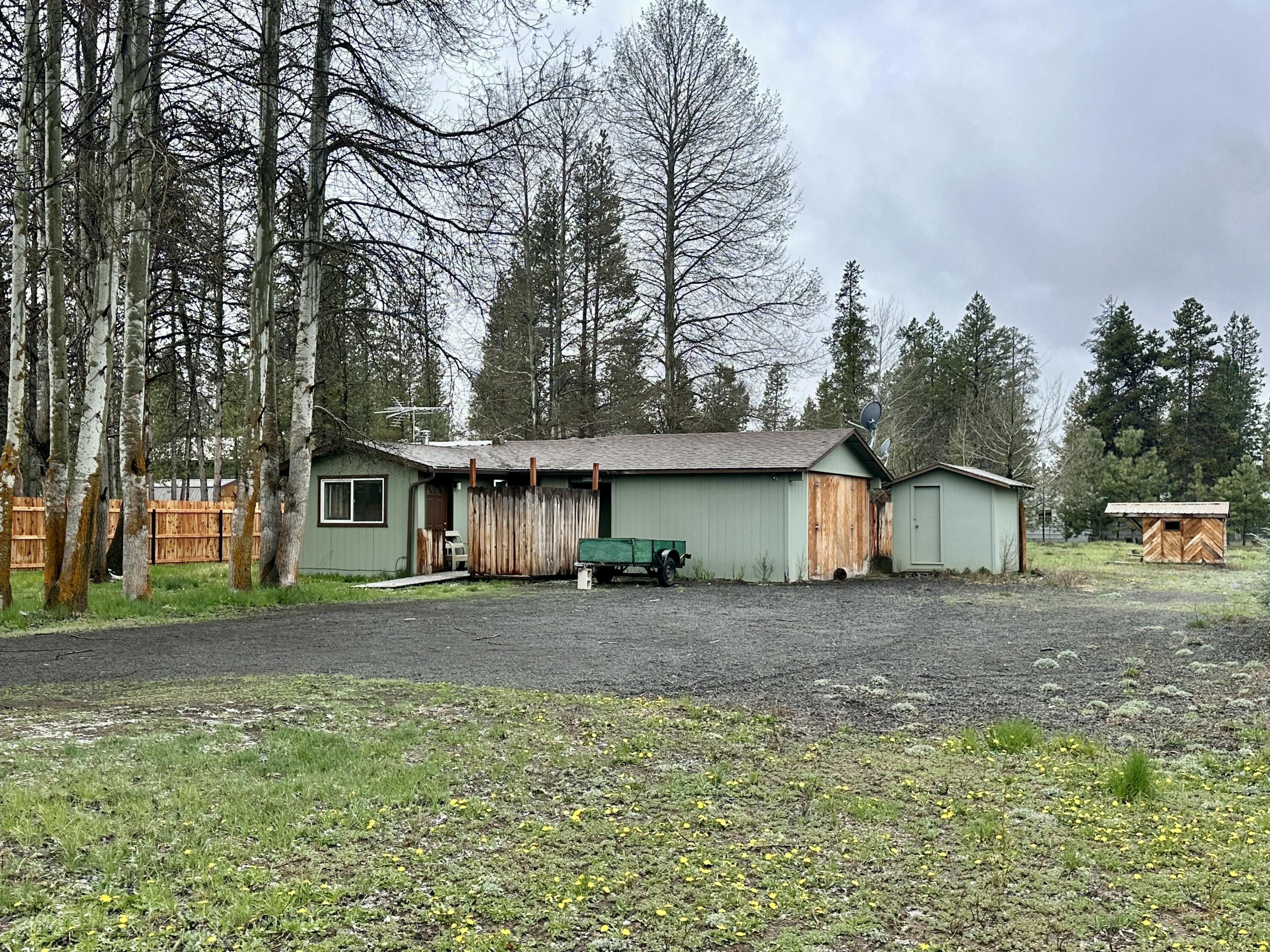 Affordable opportunity with big potential in quiet South La Pine—with public sewer and water already in place! This 2 bed, 1 bath stick-built home sits on a level, fully fenced, tree-lined lot with plenty of space to improve or expand. The single-level layout is a great starting point for a live-in flip, rental, or entry-level investment. Two outbuildings (one insulated) and a chicken coop offer added storage and functionality. Surrounded by nature and privacy, this property is ready for your tools, vision, and creativity. A rare find at this price point—don't miss the chance to make it yours!