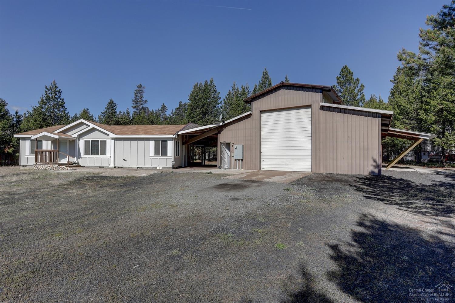 Need storage for your RV, trailers, equipment or toys or a large workspace? This property is move-in ready and has an enormous 2100+ sq ft shop that easily houses a 40 ft motorhome plus trailer and has additional bays on either side to store your other toys, tools & equipment. There is a carport that connects the home to the shop and there are 2 RV hookups - one inside the shop and the other outside. Built in '05, the home is in great shape and the interior was recently repainted. Fully fenced with a gate and 120 sq ft drywalled well house with a lean-to on one side for storage.