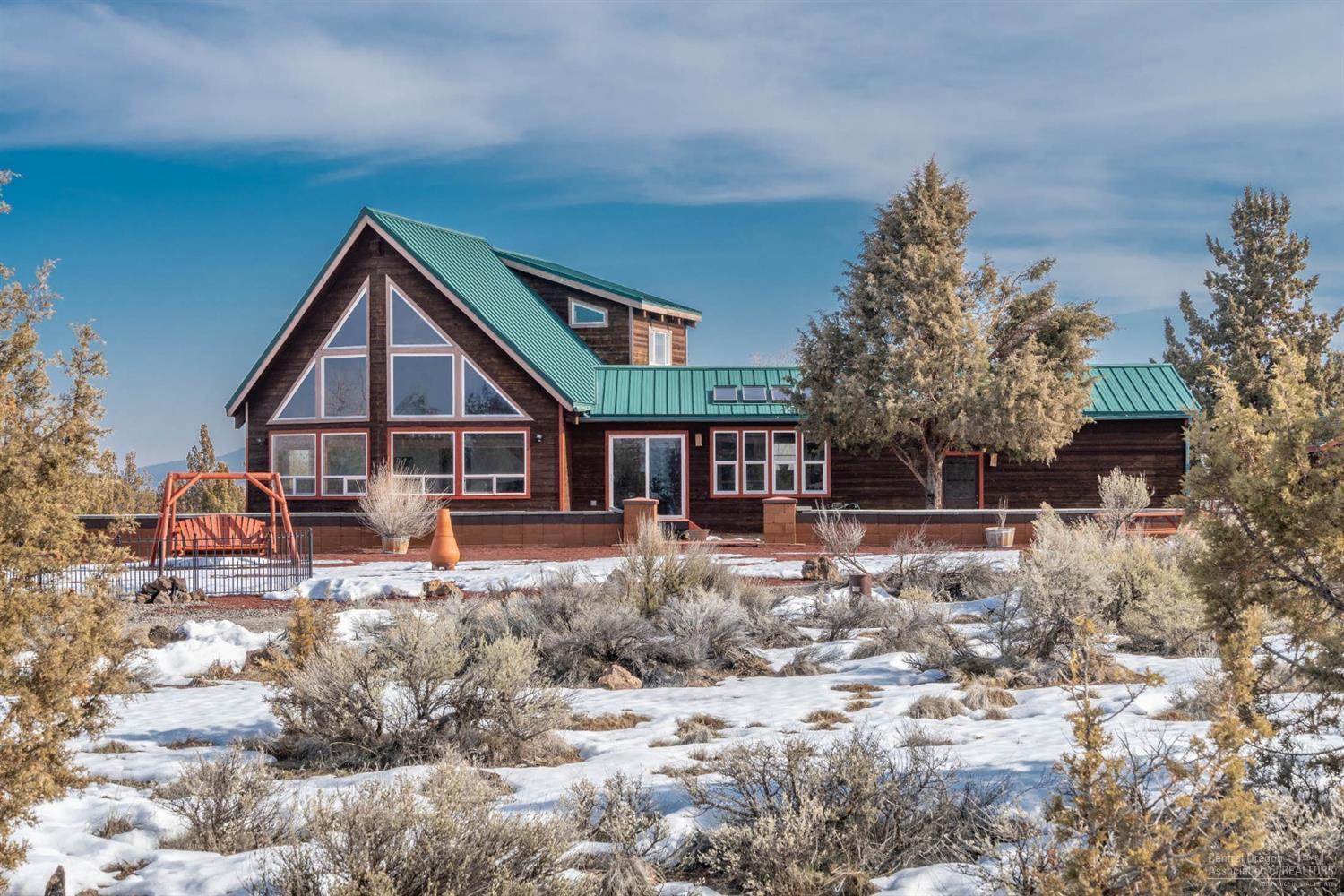 Stunning Views & Golf Too! Cedar Sided Chalet Style Home with Prow Front and Wall of Windows on nearly 5 fully fenced & gated acres in Crooked River Ranch. Cascade Mountain & Smith Rock Views. 1841 sf, 3 bedrooms and 2 full baths. 2nd Story is dedicated to the Master Suite. Heatpump for year around comfort plus a Propane stove. Private Well & Standard Septic. Easy care landscaping and large circular driveway for easy manuvering and parking. Oversized attached Garage with built in bench & cabinets. Storage Buildings and an above ground pool. Chainlink dog kennel. All appliances are included. Ranch amenities include Golf, Tennis, Swimming, Hiking, Parks, Riding Arena and Clubhouse. Horses Welcome! Close to the Deschutes River & Public land. Perfect for year aound or part time living.