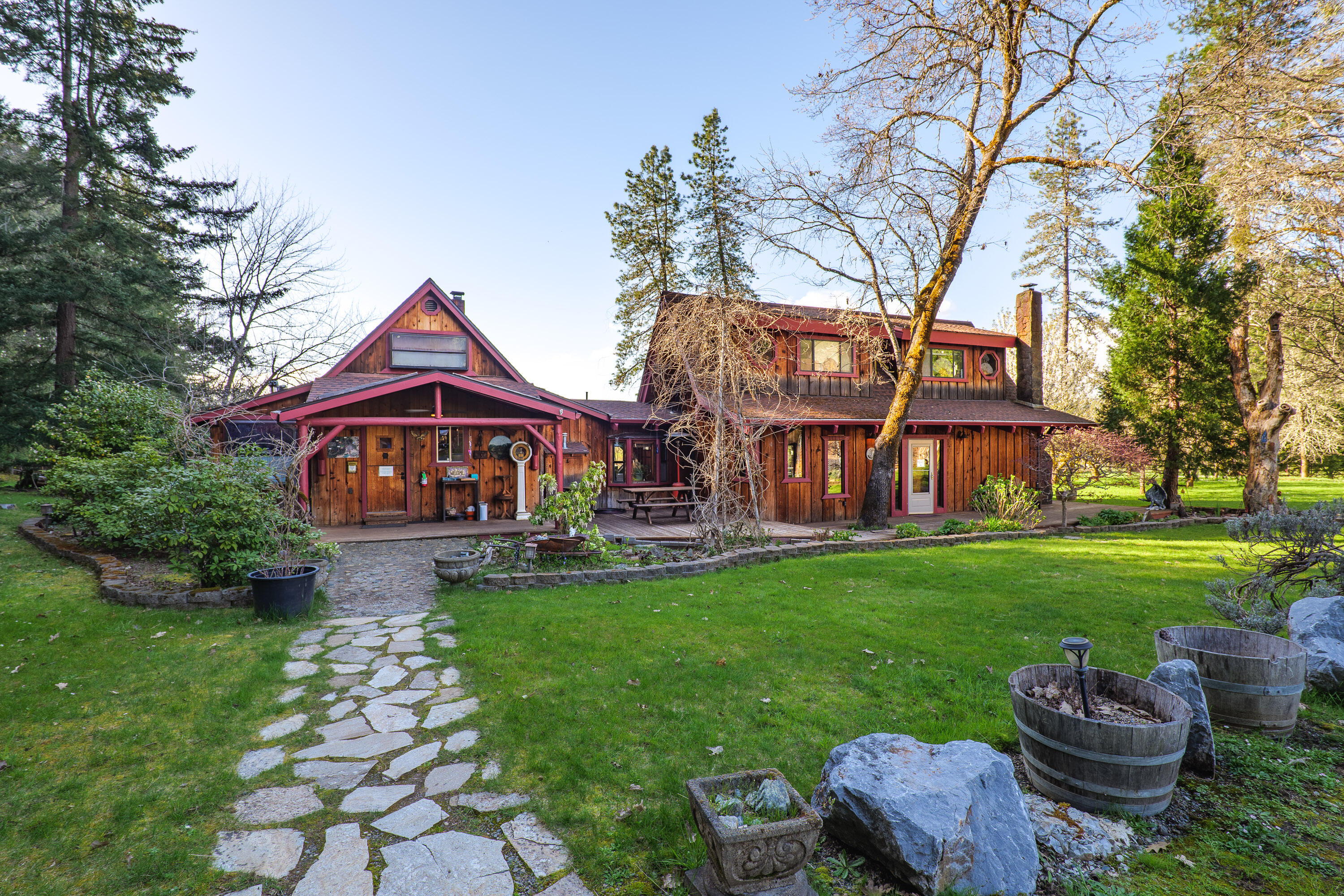 Vertical Horizons Treehouse Paradise! Situated on nearly 23 acres, this gated rural property is home to a one-of-a-kind permitted bed and breakfast, perfect for Airbnb, VRBO, or short-term rental income. Four unique treehouses dot the hillside, each with its own charm. The main house offers a peaceful retreat surrounded by lush lawns and flowering fruit trees, ideal as a private residence or the main lodge for guests. The property features a large fenced pasture, greenhouse, detached garage, spacious barn with stalls and turnout, carport, wood storage, and more. A true blend of ranch and resort living, it's perfect for those who value rural life—growing your own food, raising livestock, and enjoying privacy—while benefiting from an established income-producing resort. Located in the scenic Illinois Valley with a mild four-season climate and easy access to the Illinois River and the stunning Oregon Coast.