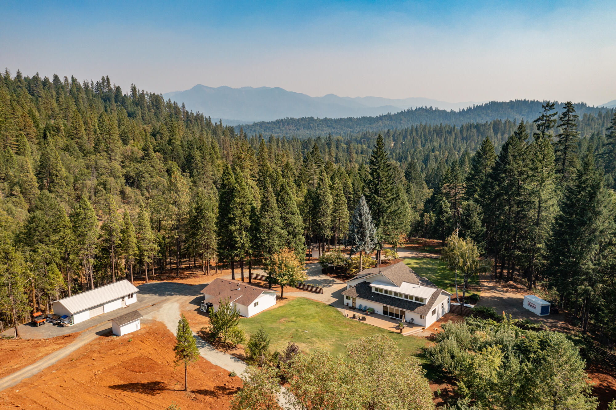 This offering provides a multitude of features: off-grid hydroelectric and grid power, exclusive privacy, direct access to vast BLM lands, irrigation rights with gravity pressurized system, creek frontage, orchard, & more. As you enter the home you are greeted by an open & bright design that embodies a modern farmhouse. The chef's kitchen has quality custom cabinetry, leathered granite counters, high-end stainless appliances, & more. The home has character throughout & includes a spacious main-level master suite, well-appointed guest bedrooms & bathrooms, bonus room, clever hidden room & more. Guest house w/ 2 beds, shop with finished office, commercial greenhouse w/ heating, ventilation & more. This property provides what might be a once in a lifetime opportunity to purchase a true turnkey Off-Grid capable hydroelectric powered property that still enjoys the convenience of grid power. The off-grid system has been fully modernized & also has a 14kw generator and battery system.