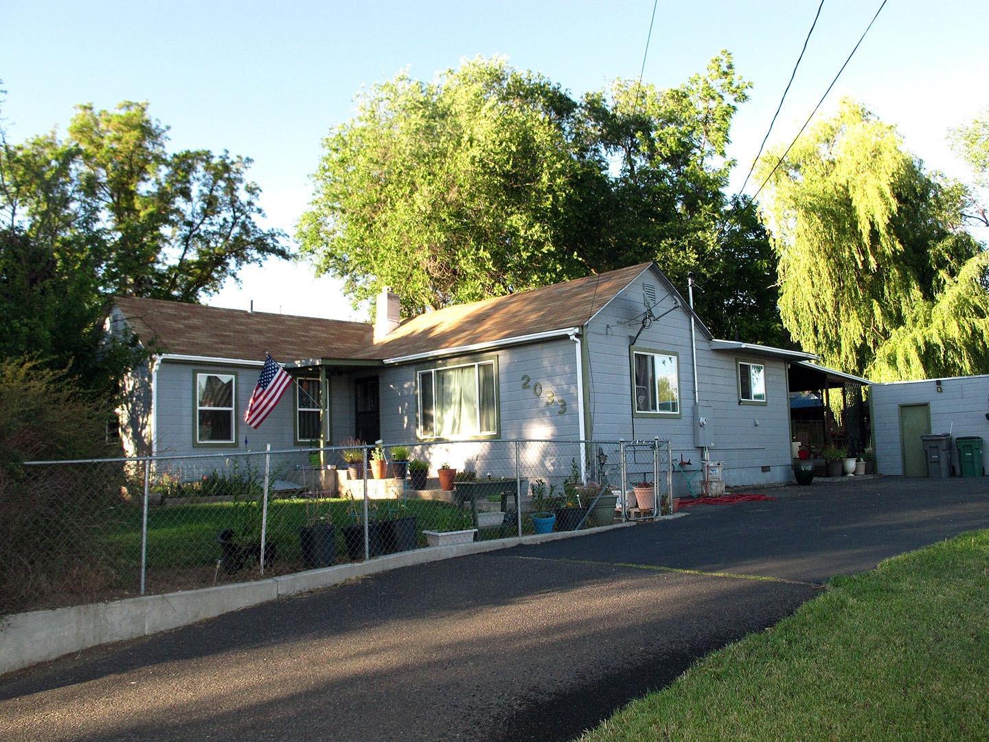 This over 1200 sq f, 3 bedroom, 1.5 bath home is located on almost 2/3 acre lot with a nice patio area as well as a great covered patio in back afternoon get togethers or relaxing evenings with friends and family. The home has had some fresh paint inside and out, laminated floors, newer windows and refinished cabinets and cupboards. There is an office/ den off the living room. The large shop has 3 bays, one with a 9 foot high door. With a few changes this could be a great home for a 4H project.