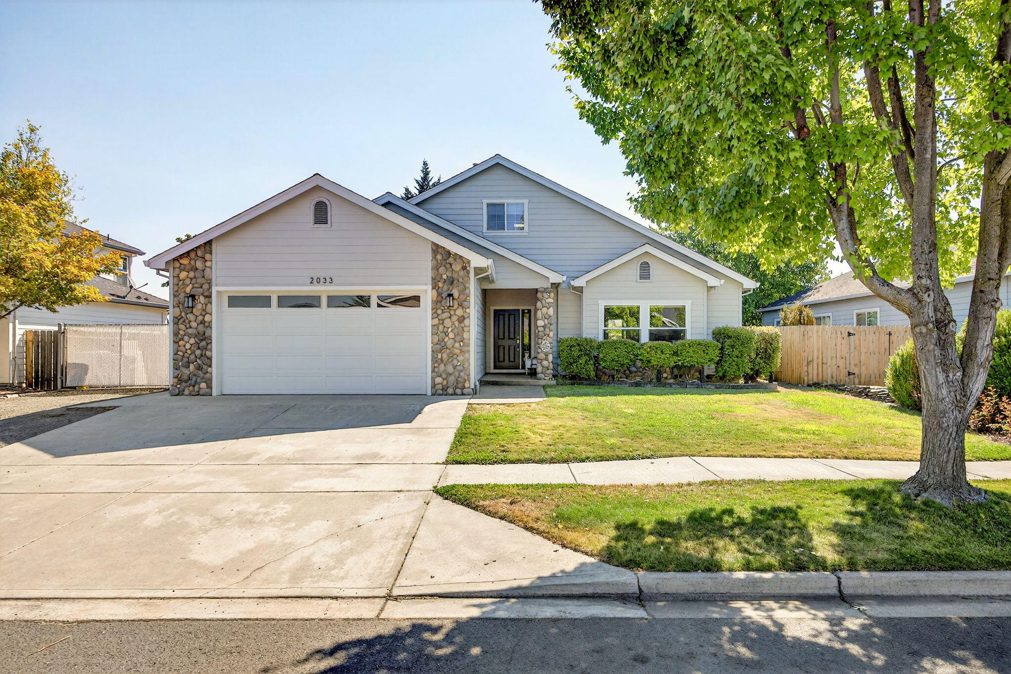 Beautifully maintained 4BD/3BA two-story home with space, comfort, and flexibility. The main level features an open floor plan with a large kitchen, stone fireplace, dining area, and living room. You'll also find two large bedrooms plus a spacious main-level primary suite with a spacious walk-in closet and updated bath featuring dual sinks and a walk-in shower. Upstairs includes a private bedroom and full bath—ideal for guests, a home office, game room, or rental income. Enjoy the finished 2-car garage, gated RV parking, and fenced backyard. Plenty of room for all your needs, whether it's multi-generational living, hobbies, or working from home. Ask about the assumable VA loan with a 2.75% interest rate! Don't miss this versatile and move-in-ready home!