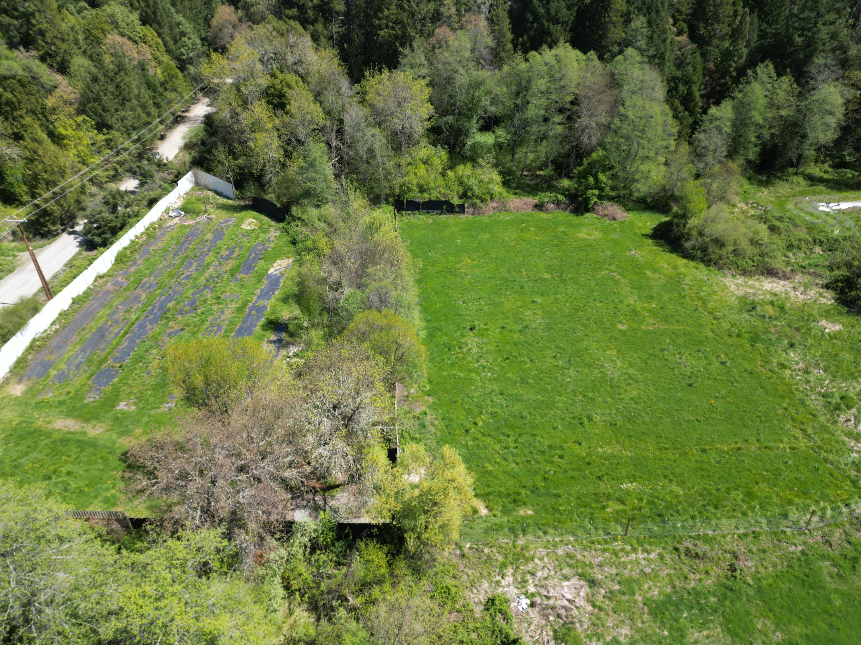 This property features numerous advantages, including open meadows suitable for gardening or horses, lush forests with established walking trails, and year-round slough with water rights for irrigation. The property includes a 10x12 shed/tiny dwelling. The well and electricity are already installed, and there is a standard septic approval on record. This property feels like your personal Campground you can enjoy while you construct your dream home. The fields below measure 100' x 200' and 200' x 200' providing tons of room for both a garden and animals. This one is a must see to appreciate the diversity and beauty that photos can't show.
