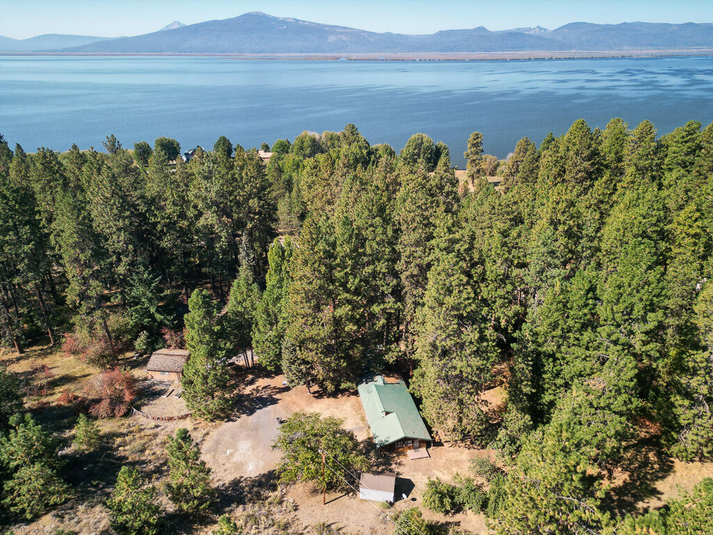Welcome to 3623 Cahuilla, the beloved ''Rock House'' where relaxation, retreat, and adventure await. Just steps from Agency Lake, this 3-bedroom, 2-bath, 1,208 sqft home blends rustic charm with modern updates. Inside, enjoy soaring clerestory windows, exposed beams, cedar tongue-and-groove finishes, LVP flooring, a newer wood stove, modern appliances, and shaker-style cabinetry. The living room is wired for surround sound. Outside offers a covered porch, new fencing, 2019 septic, detached 2-car garage on its own lot, and a finished 8x16 shed—perfect as a studio, workshop, or storage. Fruit trees include cherry, pear, two apple, and plum. HOA covers road maintenance, snow plowing, and community well—no water bill. Residents enjoy lake access, boat ramps, and parks. With a durable metal roof and prime location near the Wood River Wetlands, this home is ready to enjoy for years to come.