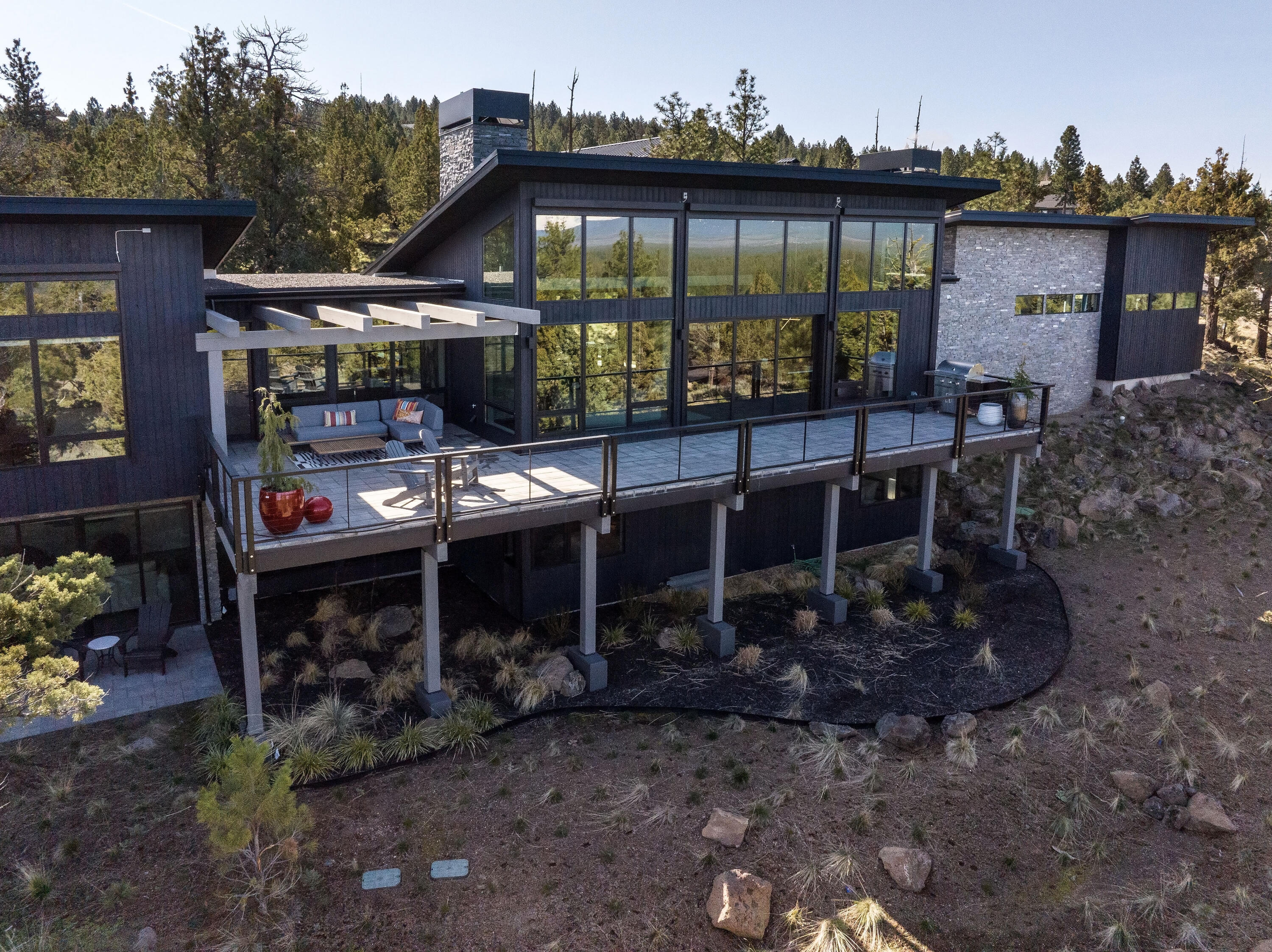 Nestled in the prestigious North Rim community, this luxurious home offers breathtaking panoramic views of the Cascade Mountains, visible from the moment you step inside. Expansive 12-foot sliding glass doors frame vistas from Mt. Bachelor to Mt. Adams, perfectly blending nature with modern elegance. The great room features a sleek Isokern gas fireplace, while the gourmet kitchen impresses with a 12-foot leathered quartzite island, high-end appliances, and thoughtful design for effortless entertaining. The main level also includes a refined office with custom built-ins and a serene primary suite with a private sitting room, dual-sided fireplace, spa-like ensuite, and his-and-hers walk-in closets. The lower level features two bedrooms, a bonus room with built-ins, quartz countertops, wine cooler, and patio access. The oversized garage includes epoxy floors, a work station, dog wash, and mechanical room. Residents enjoy access to a private lodge, tennis/pickleball court, and parkland.