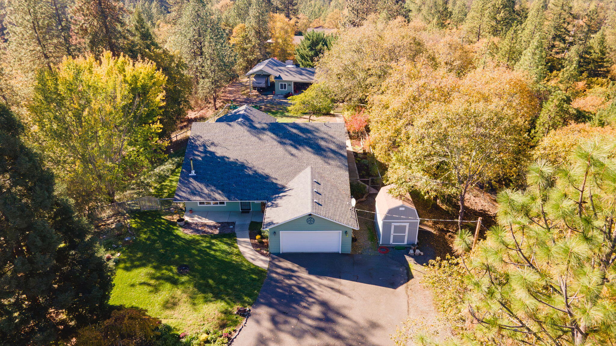 This spectacular property is the setting for a spacious and versatile home on five private acres just minutes from town. With 5 bedrooms, 3 full baths, and 2 primary-style suites, this layout works beautifully for multigenerational living or anyone needing extra space for guests or that work-from-home life. The open kitchen and dining area connect to dual living spaces, giving everyone room to spread out while still feeling connected. The property has seen thoughtful upgrades, including new french doors and sliders, a water softener system, and added outbuildings- one with full power, ideal for hobbies or storage. Outside, a pool and large fenced yard create the perfect spot for gatherings and outdoor fun. There is also a detached shop with RV parking and plenty of space for projects or toys. Private, peaceful, and move-in ready, this home offers sought-after flexibility and comfort, all in a country setting close to conveniences.