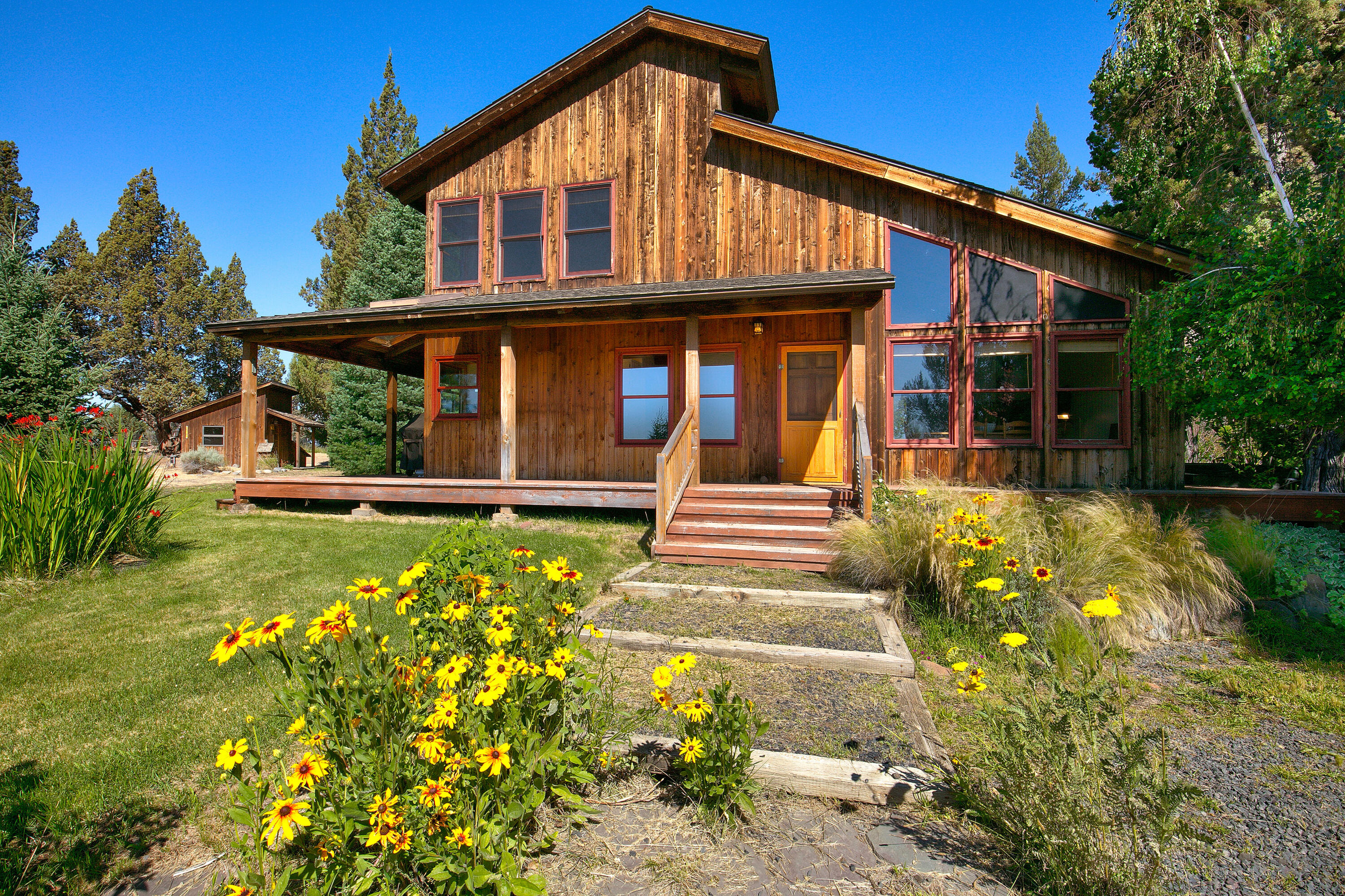 Welcome to 65701 Twin Bridges Road, where rustic charm, wide-open space, and a little country soul come together, all just 15 minutes from downtown Bend. Discover your ideal retreat on 7 stunning, fully fenced acres with breathtaking views of the Cascade Mountains, in the heart of Tumalo, complete with 6 acres of TID irrigation. This inviting, 1,400 square foot rustic Northwest-style home features 2 bed / 2 baths, creating a warm and cozy atmosphere, all while offering incredible potential for enhancement. The property also includes a newly built detached two-car garage, which features a spacious one-bedroom, one-bath studio with a versatile upstairs bonus room, ideal for guests, rental income, or as a dedicated workspace. Also located on the property is a usable barn for farm equipment or livestock. Whether you are dreaming of a few chickens, a horse property, a private haven or just want to garden, this property has the land, the layout, the water, and the heart to make it happen.