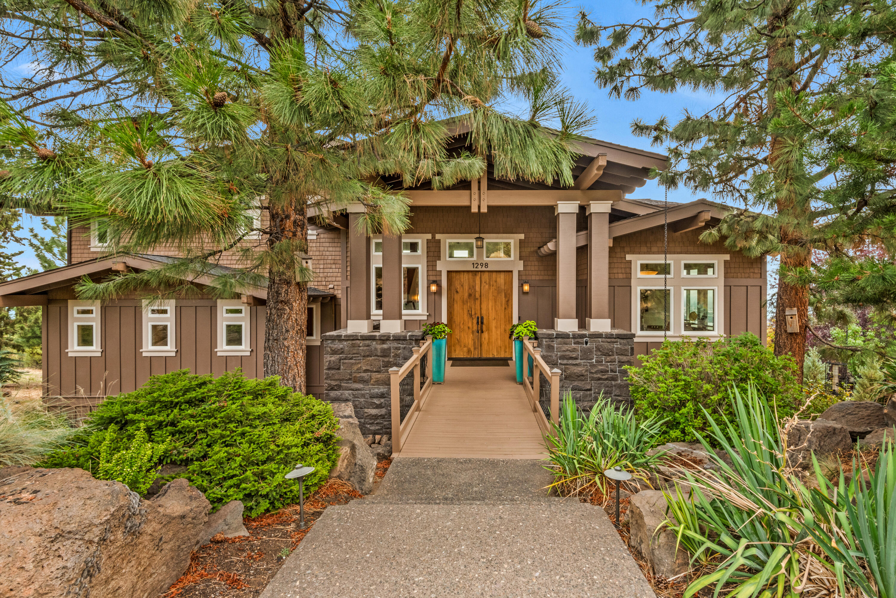 This custom Craftsman home blends exceptional architectural features, comfort, luxury, convenience, and technology with amazing views of Mt. Jefferson, Mt. Hood, and Smith Rock. The main level boasts a 20 ft. ceiling great room, chef's kitchen with large island and dining area, formal dining room, primary suite, laundry room, half-bath, and huge deck. A second suite is on the lower level, along with the wine cellar and garage. Two additional bedrooms, a media room, and dedicated office are on the upper level. Elegant touches include Brazilian cherry floors, walnut doors, granite countertops, two fireplaces, and a ''dumbwaiter''. This high-tech home features solar panels, built-in speakers throughout, user-friendly ''smart'' control of entertainment, security, lighting, HVAC, plumbing, home access, and irrigation, topped with a 4K theater experience in the updated media room. The huge, renovated garage has heating/cooling, bright lighting, epoxy flooring, a workshop, and extensive storage.