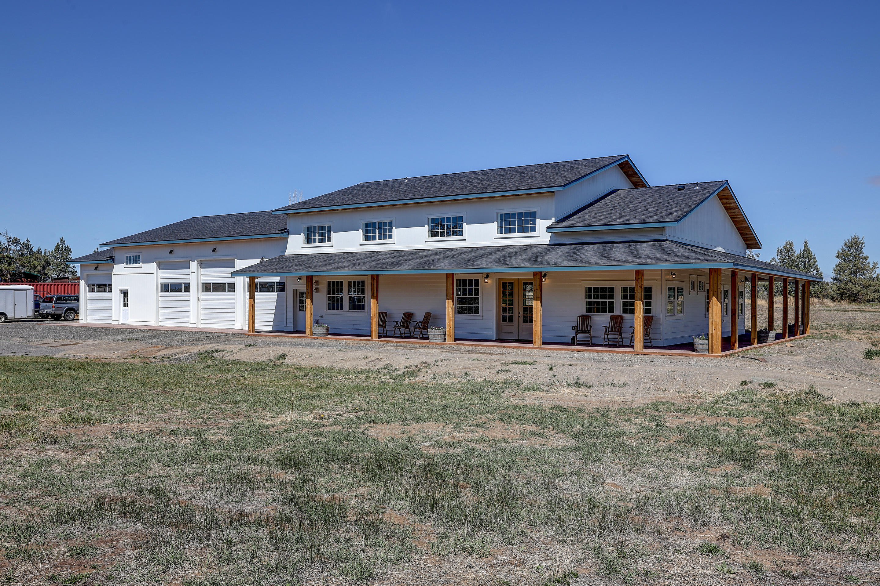 Welcome to a sneak peak of the 55th Farmhouse! Perfectly situated at the end of a private road sits this beautiful white farmhouse accented by a large covered wrap around porch.  Full window grids add to the charm of the house. With over 4 acres of irrigation rights, the supporting acreage is a blank canvas ready for your finishing touch. It's the perfect compliment to this dreamy farmhouse! The entry brings you into a grand great room with a ceiling height at nearly 21 ft.. The main level has 2 en suite bedrooms and a 3rd bedroom with a separate full bath. You'll also admire the light and bright office and the well appointed laundry/mudroom with its own exterior entrance. Upstairs you'll find a large open balcony and 2 bedrooms with a jack and jill bath. The finish detail throughout has its own wow factor! The attached garage/shop is roughly 2,400 sq ft. with 5 garage doors and it's own 200 amp service. Both the house & shop are flooded with natural light. The full reveal is waiting!